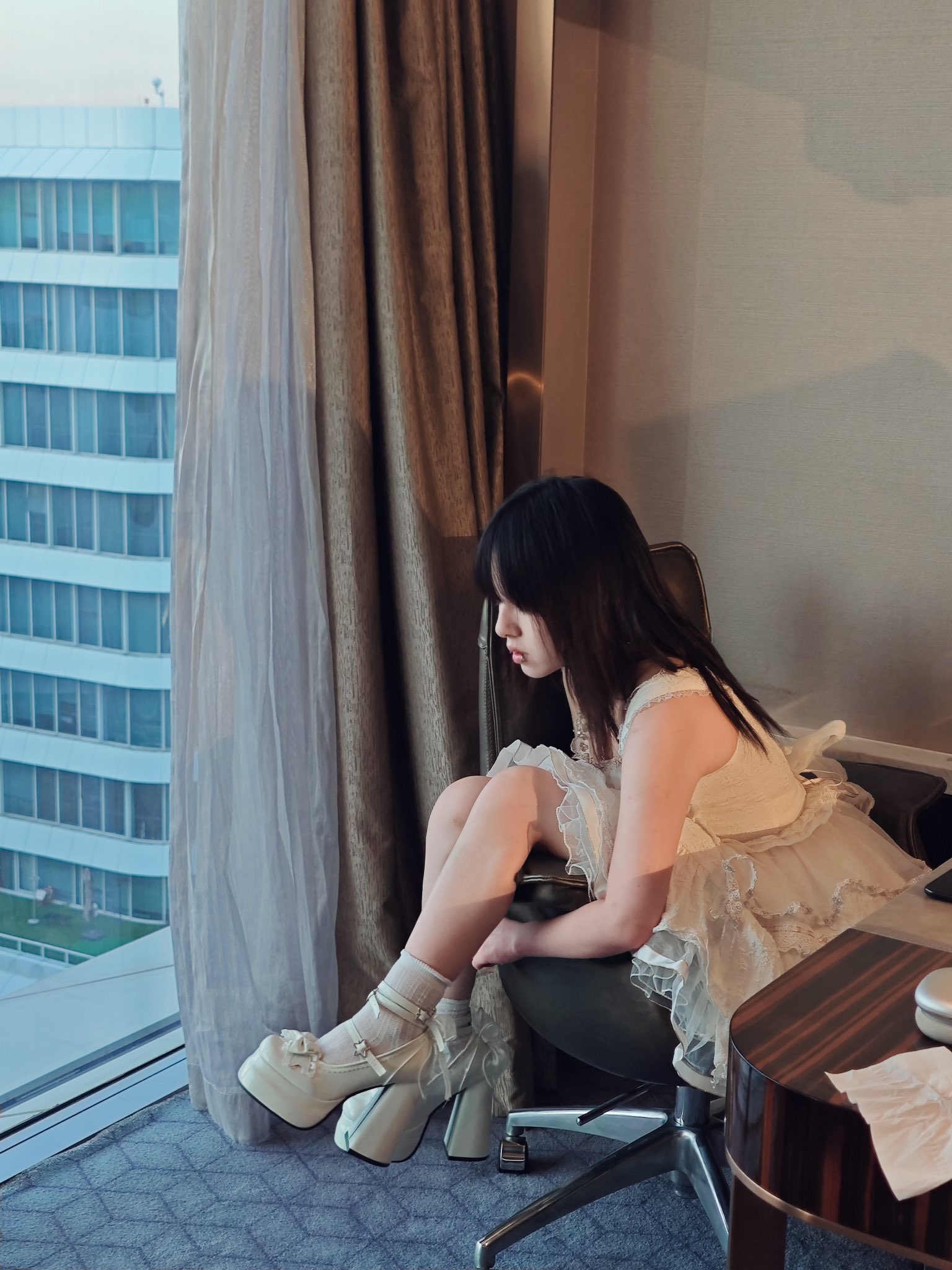 穿着白色衣服的女人坐在椅子上。