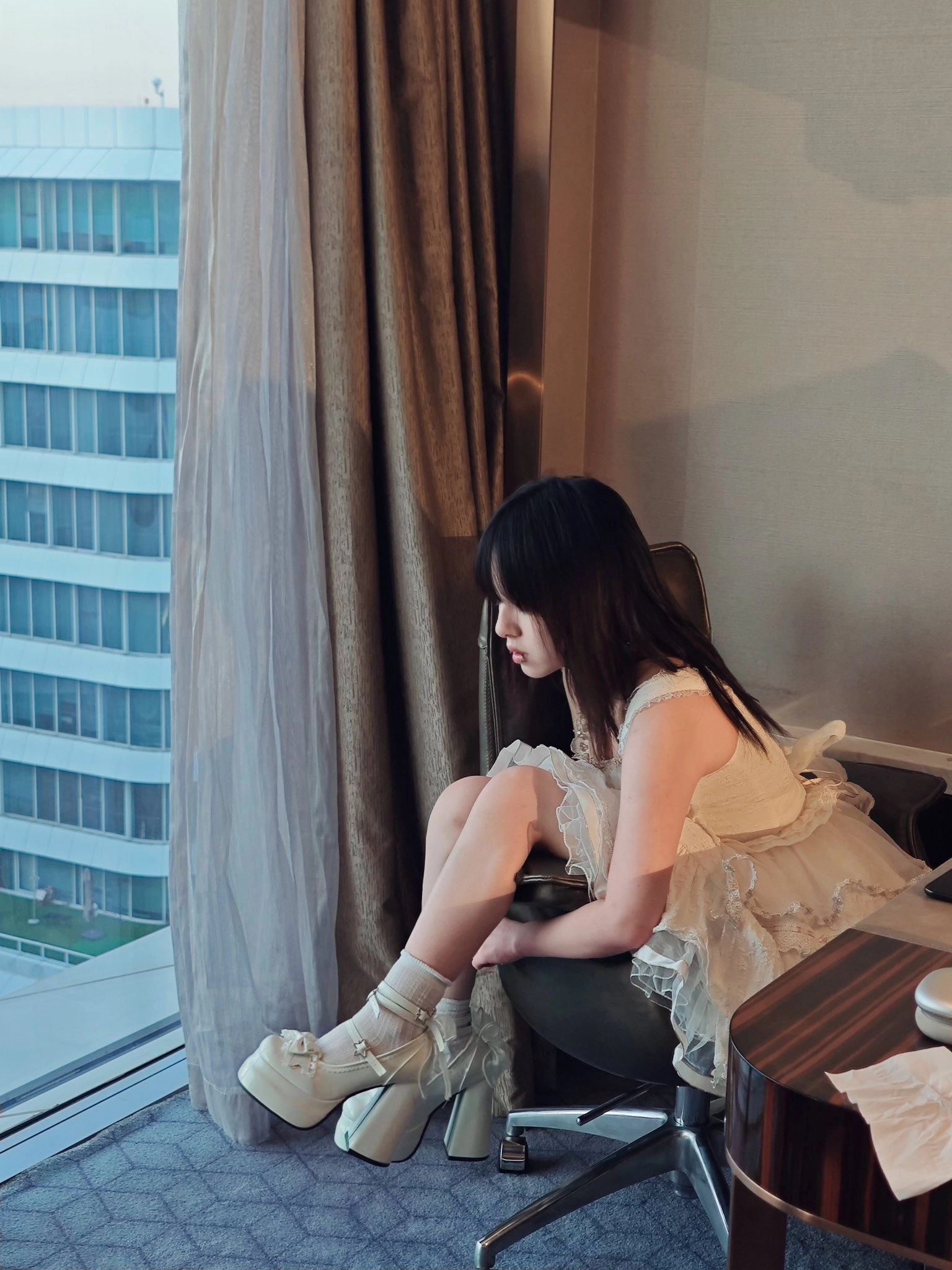 穿着白色衣服的女人坐在椅子上。