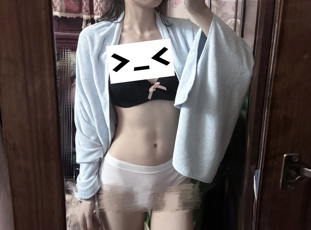 女人穿着一个白色的胸罩和一个蓝色的衬衫。