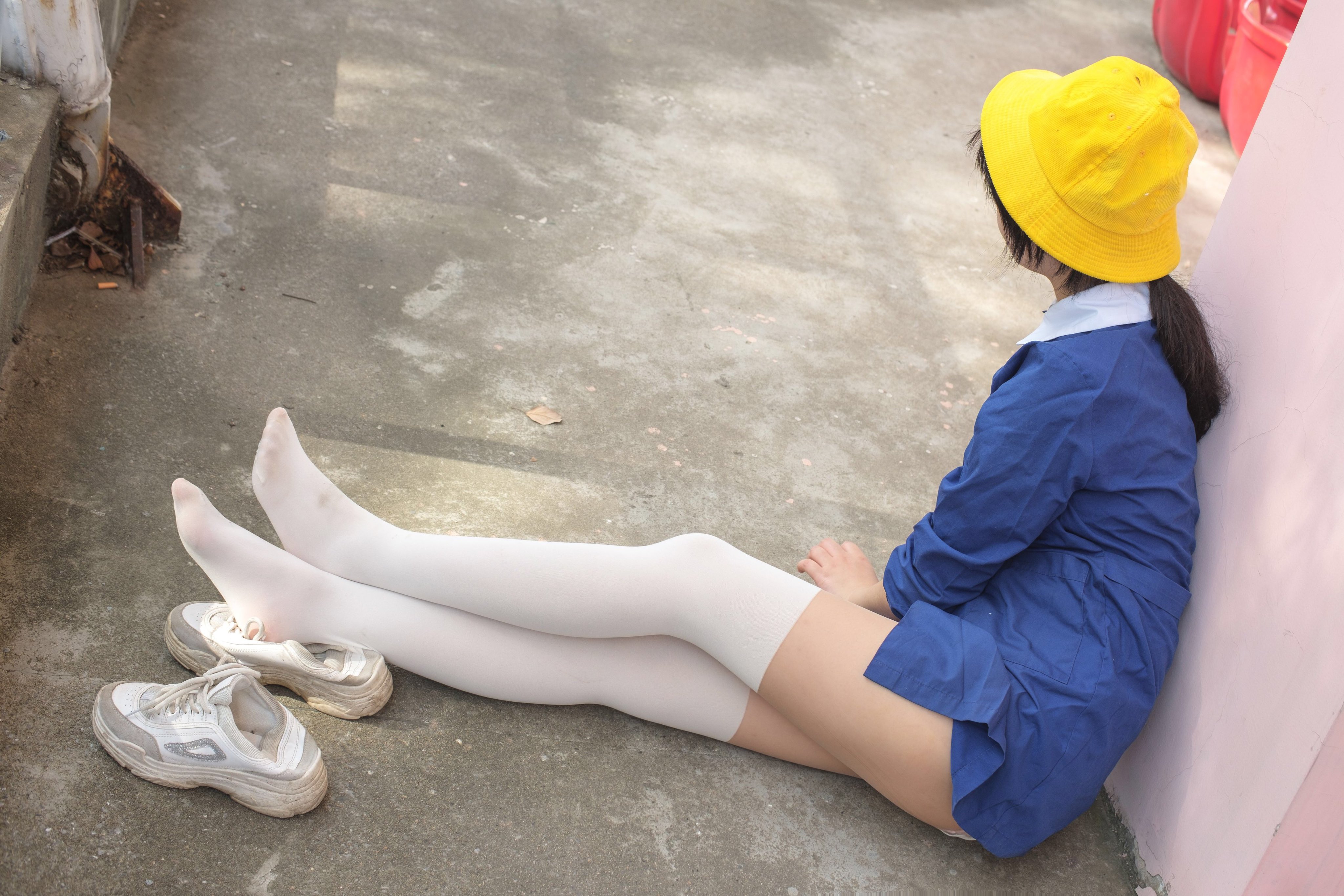 穿着白色衬衫和蓝色衬衫的女人坐在地上。