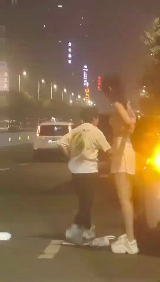 男人和一个女人晚上站在街上。