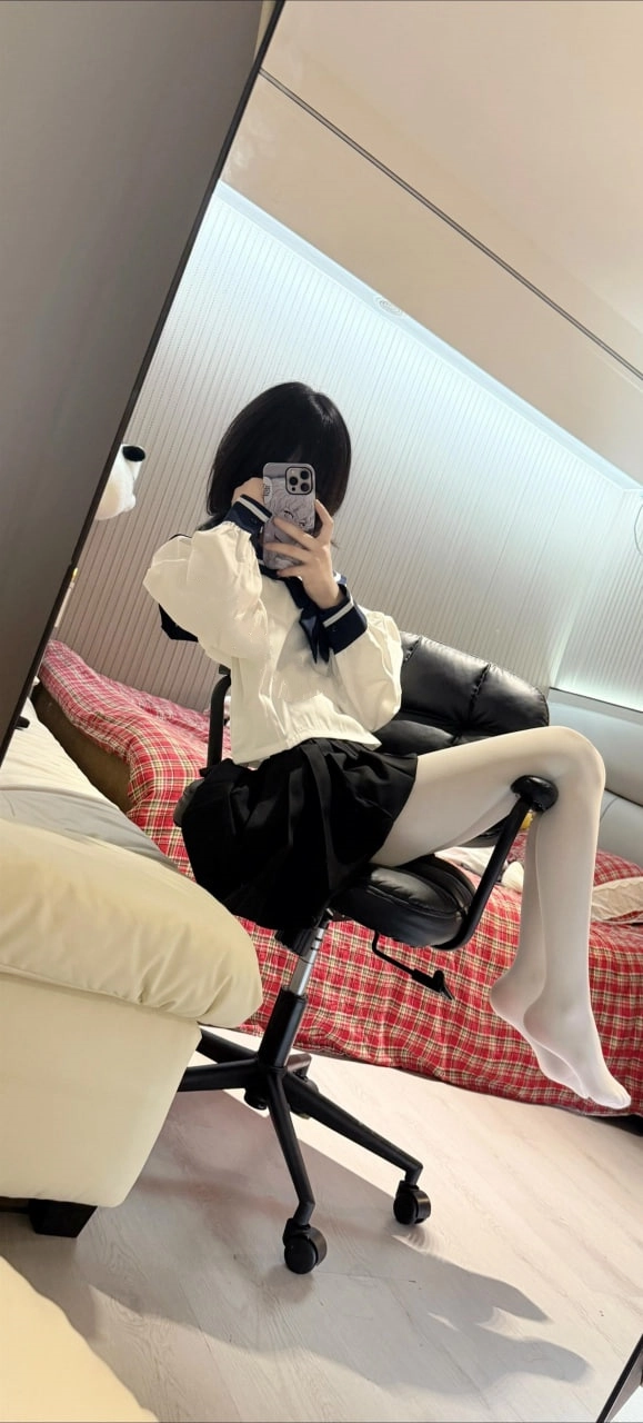 一位穿着黑色衬衫和白色衬衫的女人拍了一张自拍。