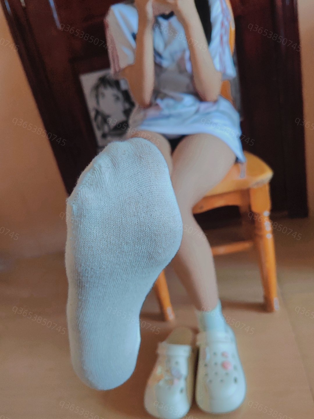 穿着白色衬衫和白色鞋子的女人坐在椅子上。