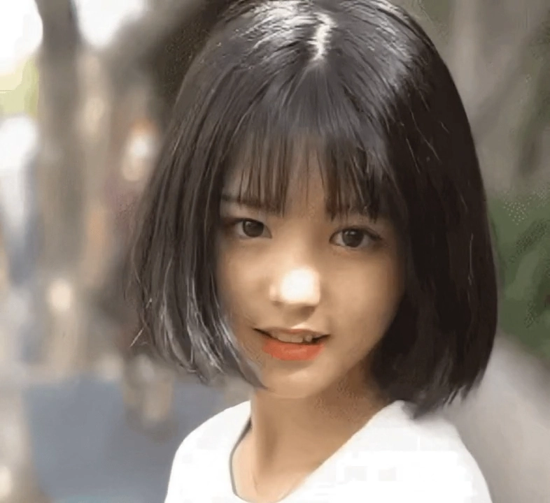 年轻的女人,短发和粉红色的唇膏微笑。