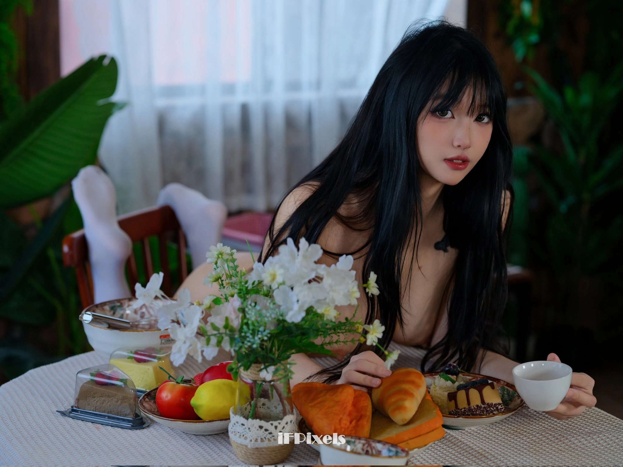女人坐在桌子上,拿著一盤食物。
