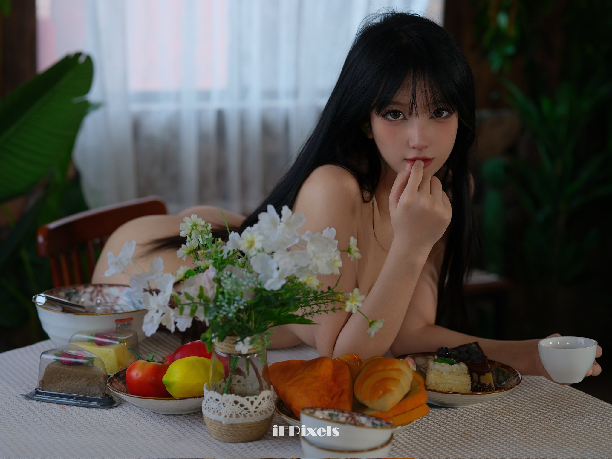 女人坐在桌子上,拿着一盘食物。