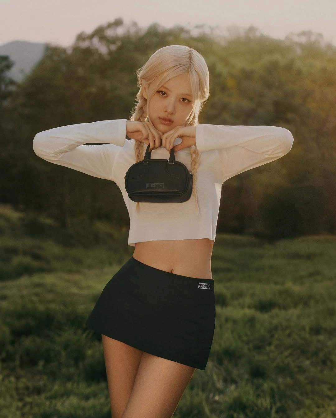 穿着白色衬衫和黑色裙子的女人拿着一个黑色钱包。