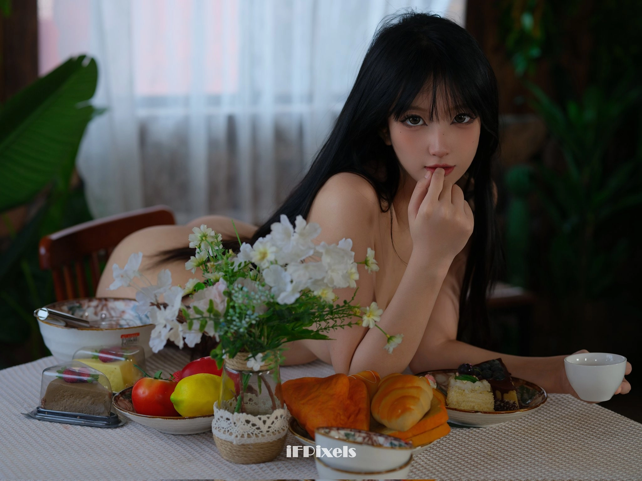 女人坐在桌子上,拿著一盤食物。