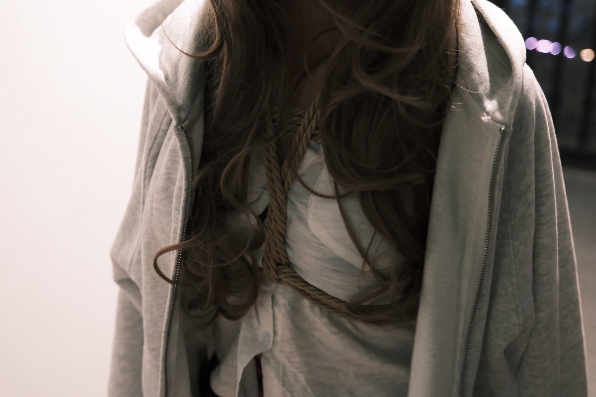 女人穿着一件白色的胡迪和一件白色的裙子。