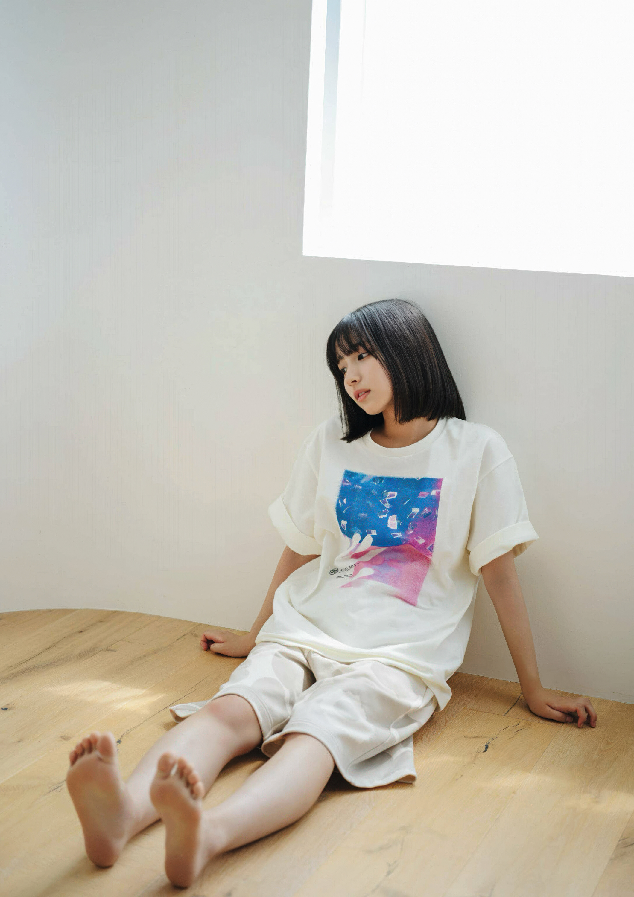 穿着白色衬衫的女人坐在木地板上。