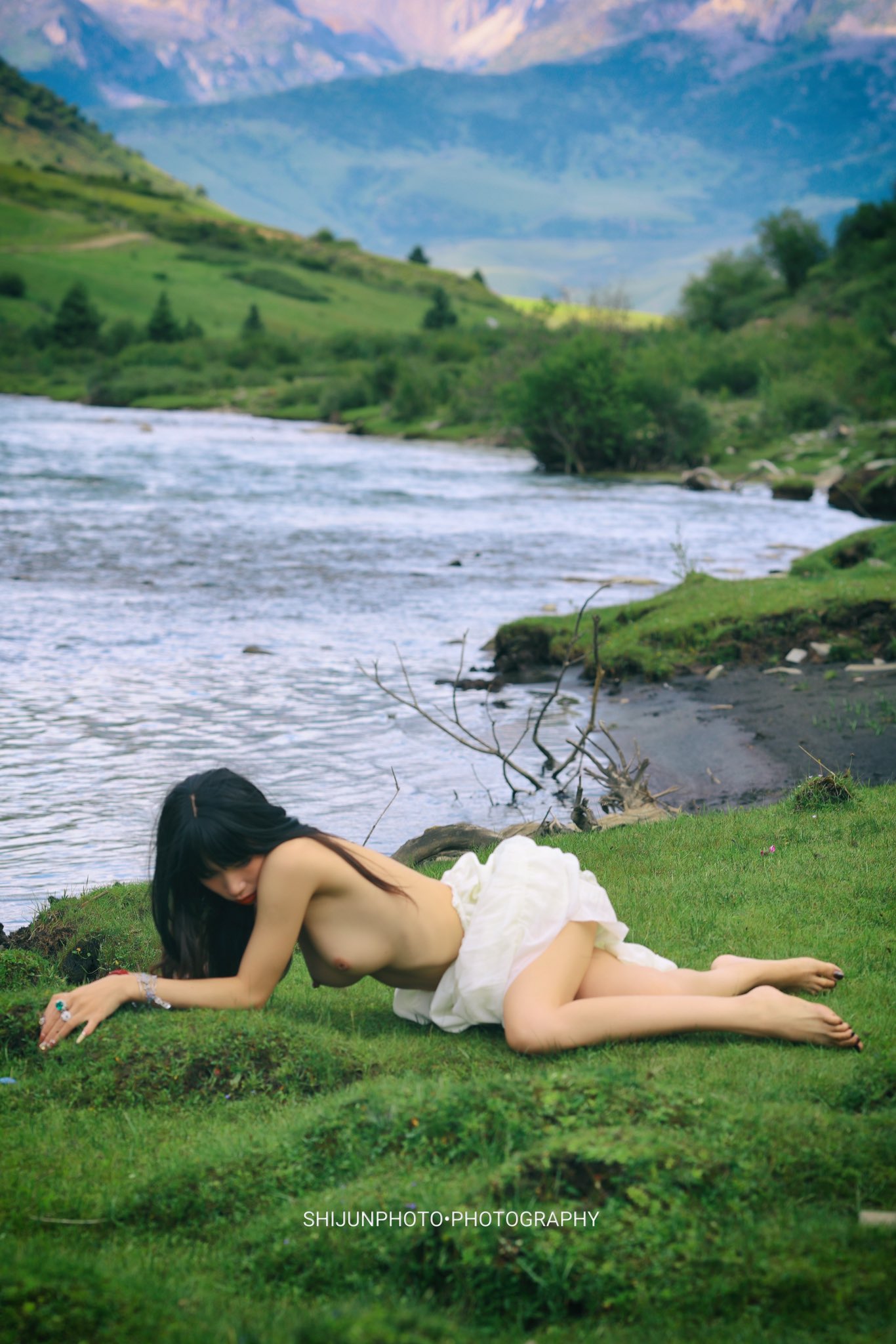 女人躺在河边的草地上。