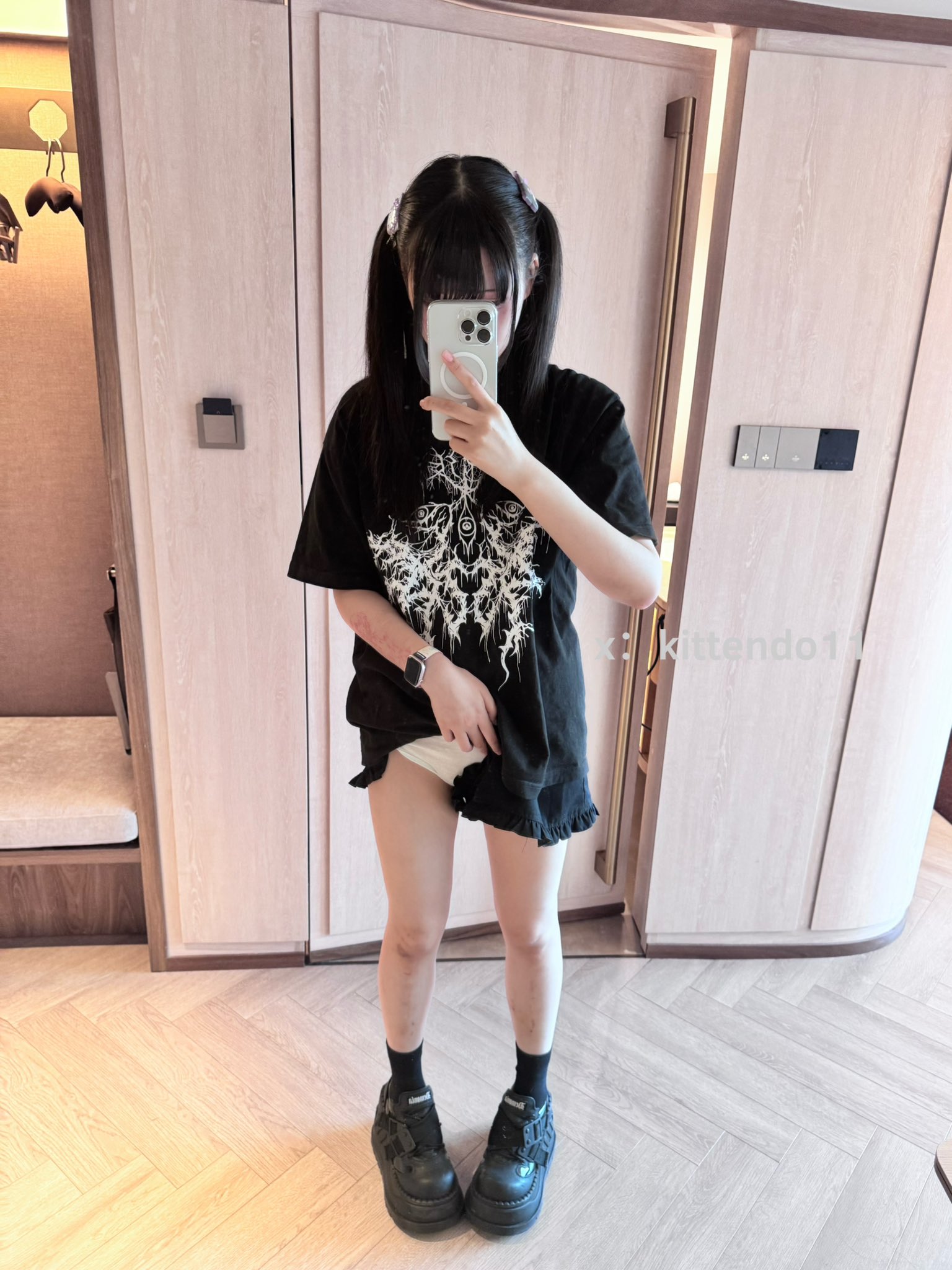 一位穿着黑色衬衫和黑袜子的女孩拍了一张自拍。