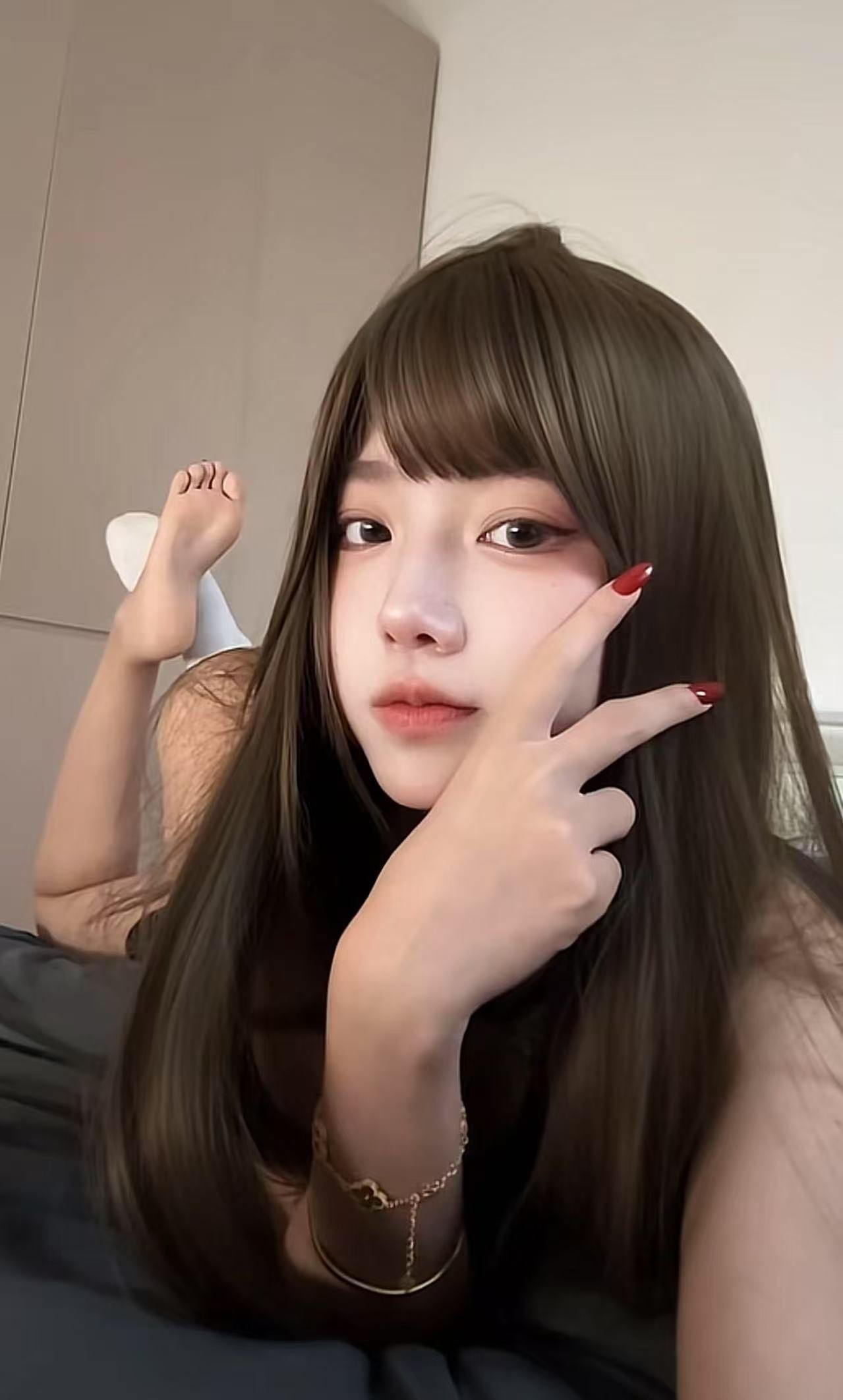 长头发和红色指甲的女人做了一个和平的信号。