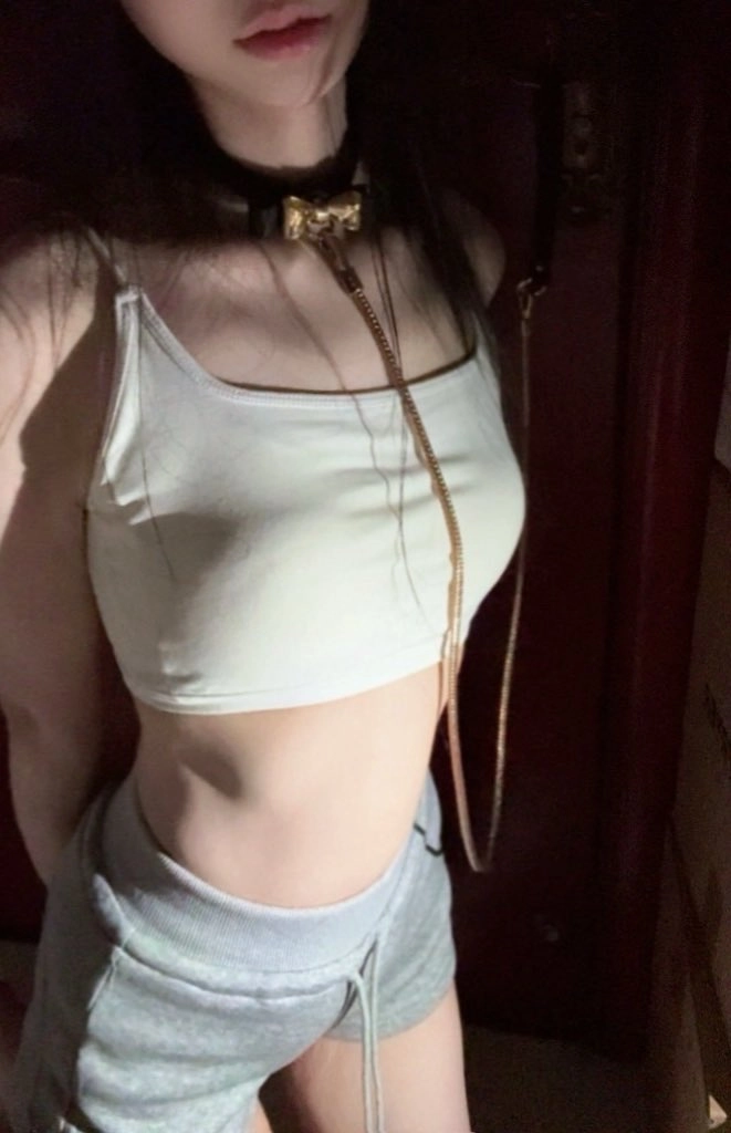 女人穿着一件白色衬衫,脖子上有一条链子。