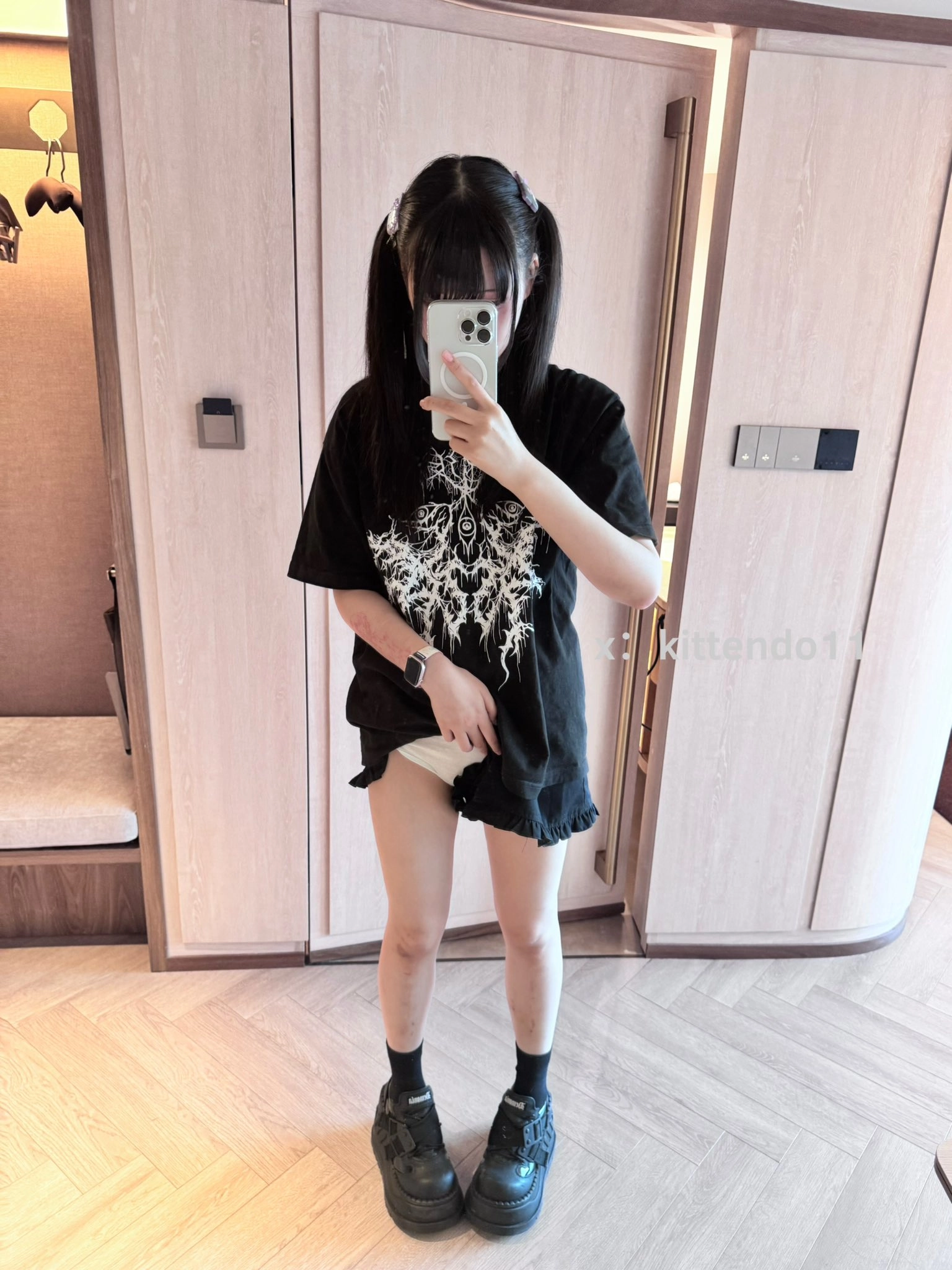 一位穿着黑色衬衫和黑袜子的女孩拍了一张自拍。