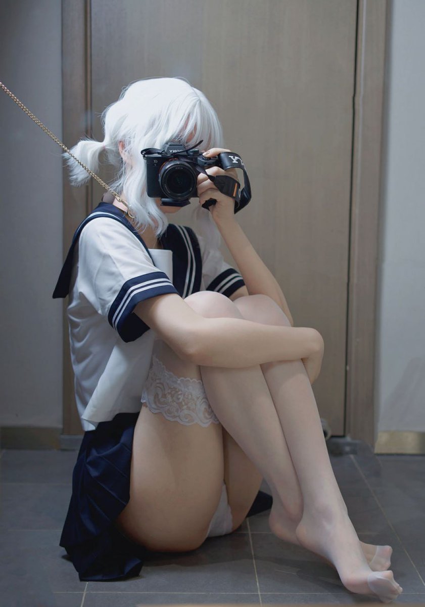 一位穿着白色衬衫和黑色裙子的女人正在拍照自己。