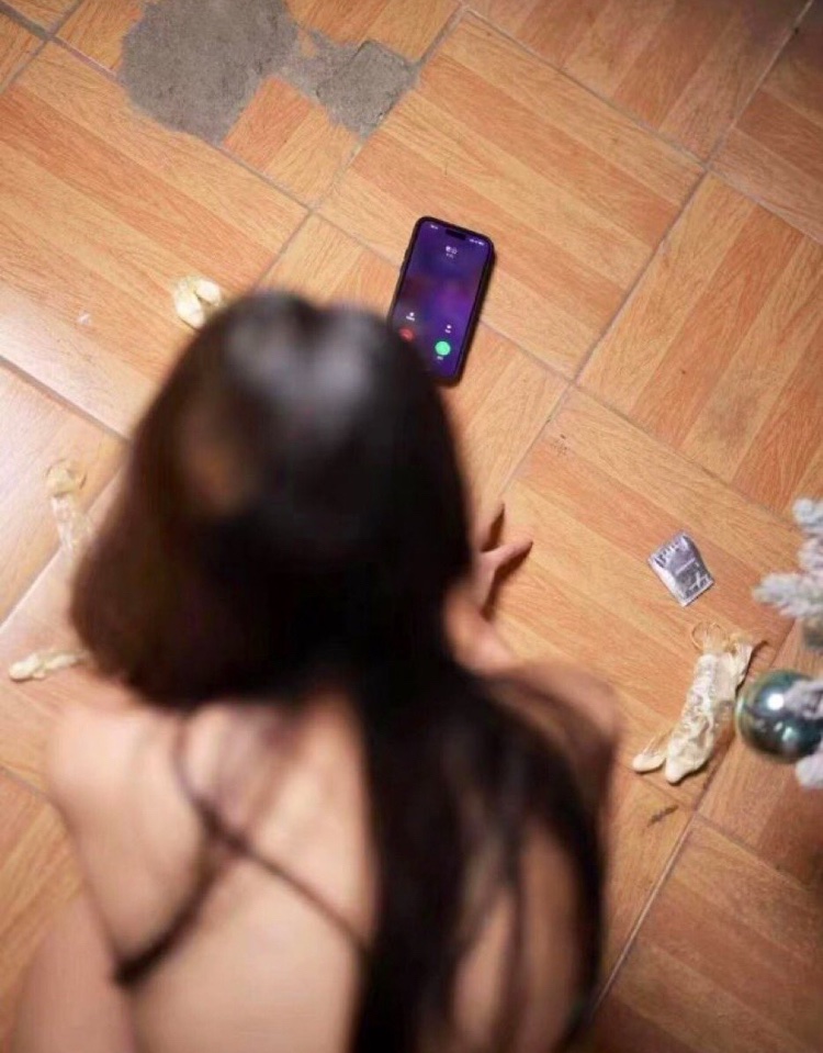 女人坐在地板上,拿着手机。