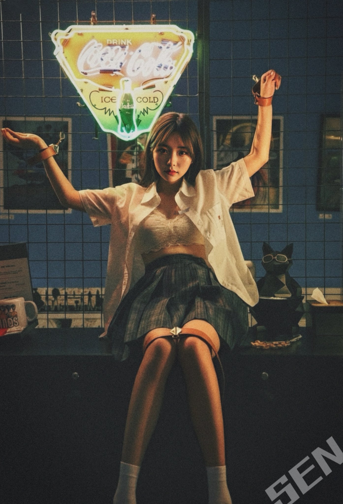 穿着白色衬衫和黑色衬衫的女人坐在桌子上。