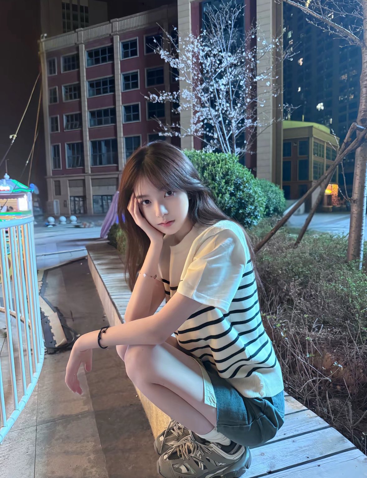 晚上,女人坐在一个凳子上。