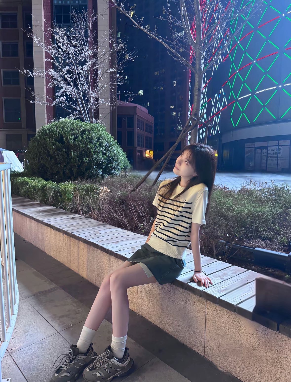 晚上,女人坐在一个凳子上。