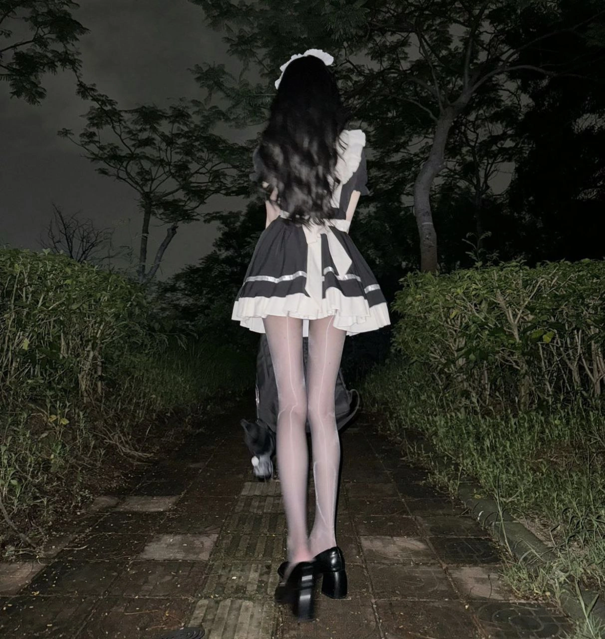 穿着女仆的服装的女人走了一条路。