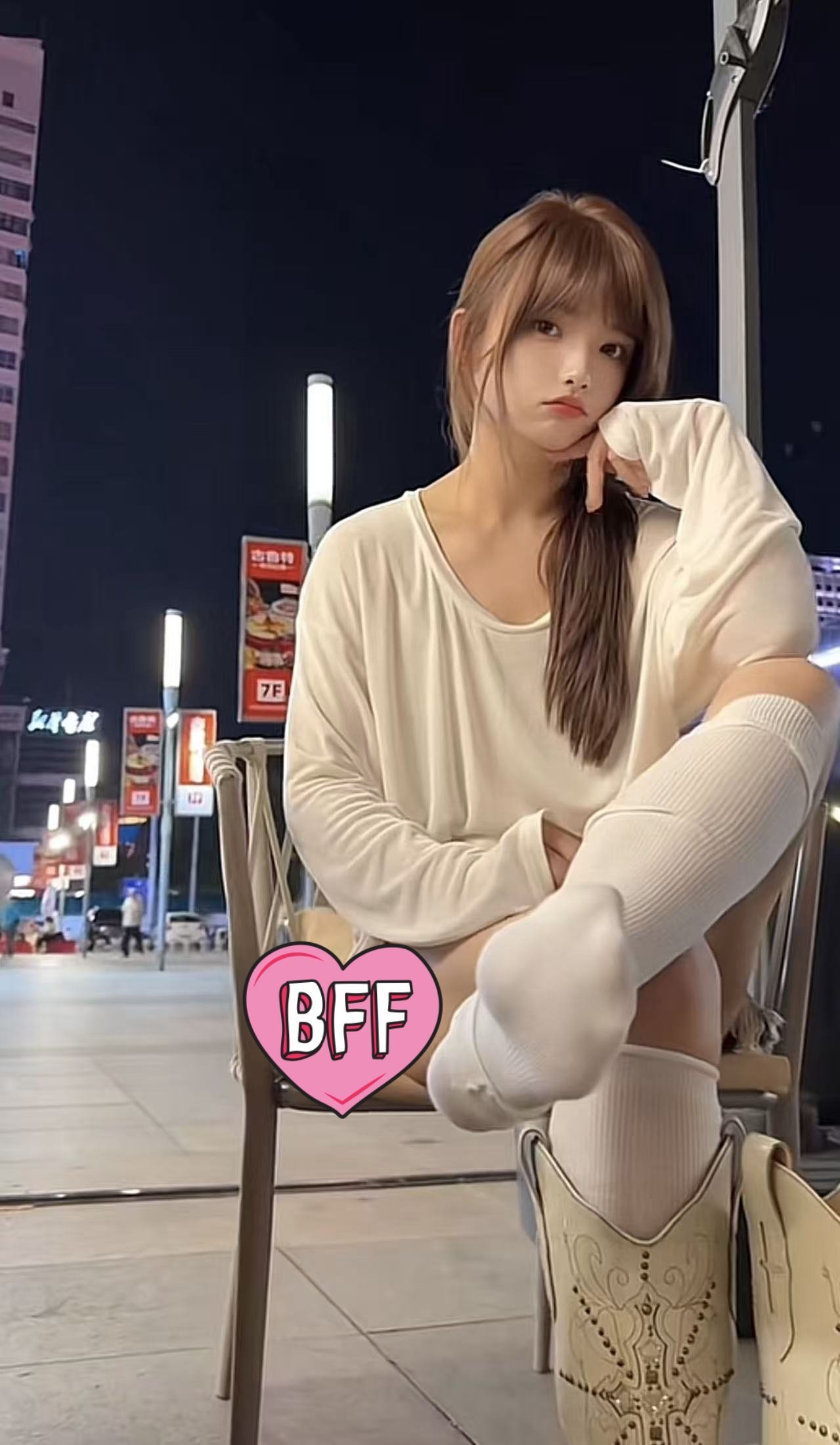 女人坐在椅子上,角落有一个粉红色的心脏。