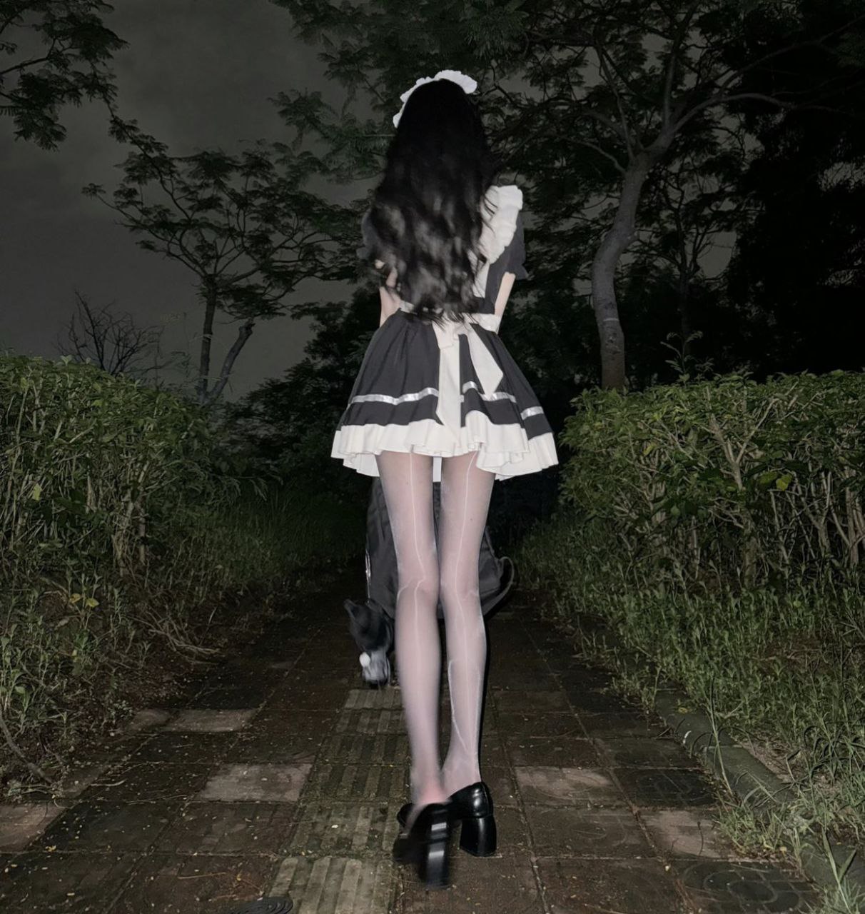 穿着女仆的服装的女人走了一条路。