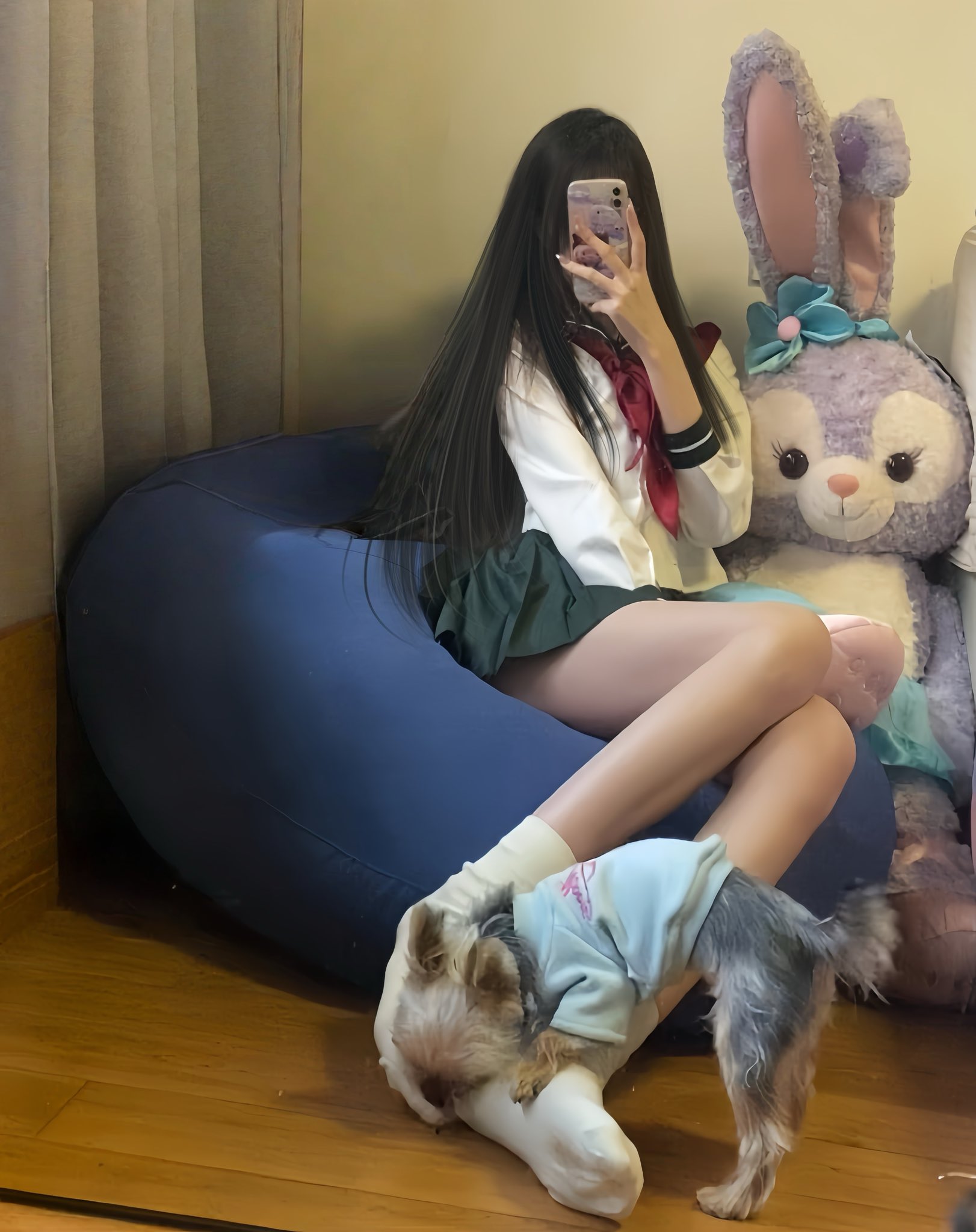 女孩穿着学校制服,拿着手机。