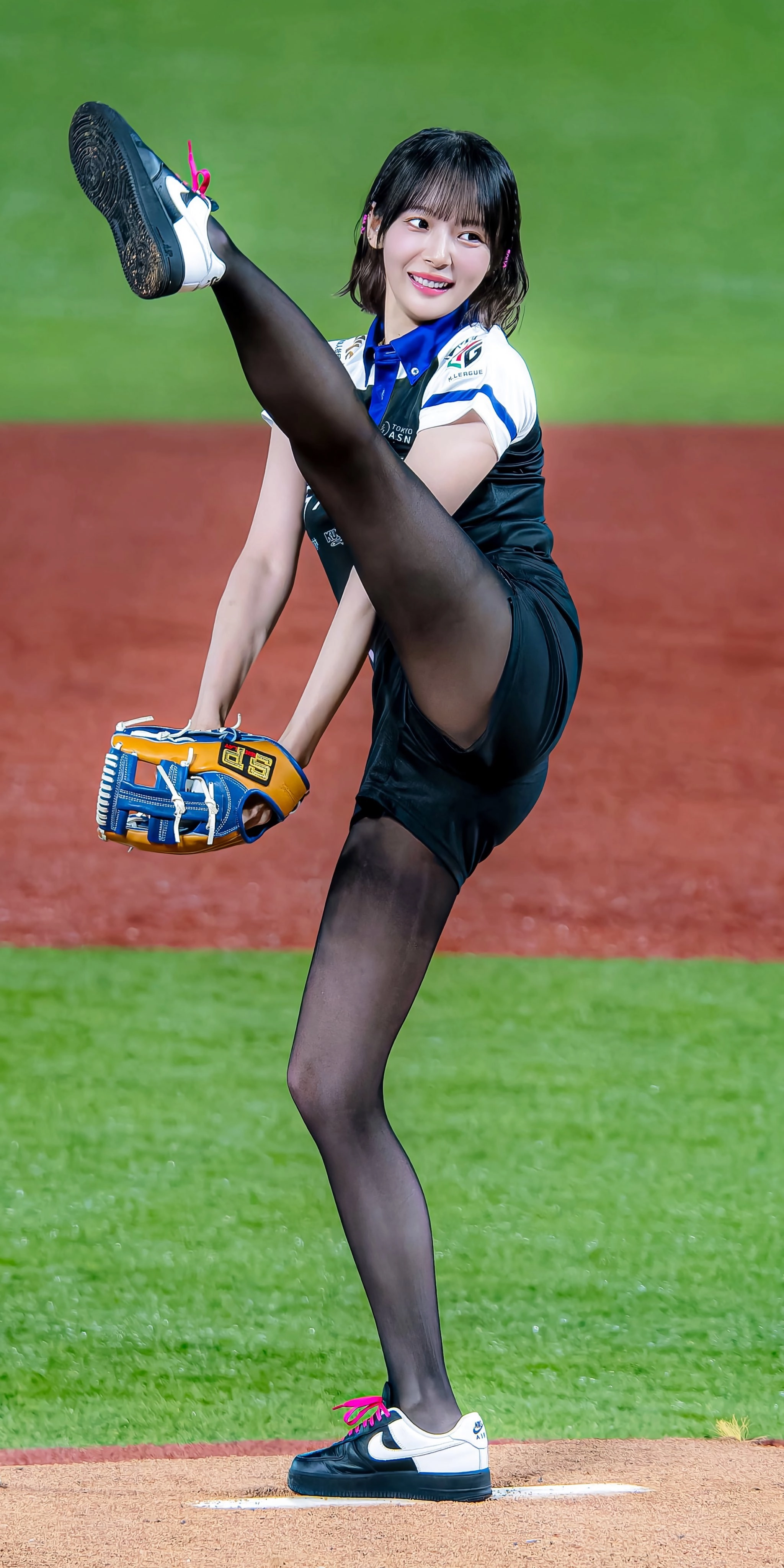 一位穿着黑色衬衫和黑色袜子的女人在拿棒球手套时踢她的腿。