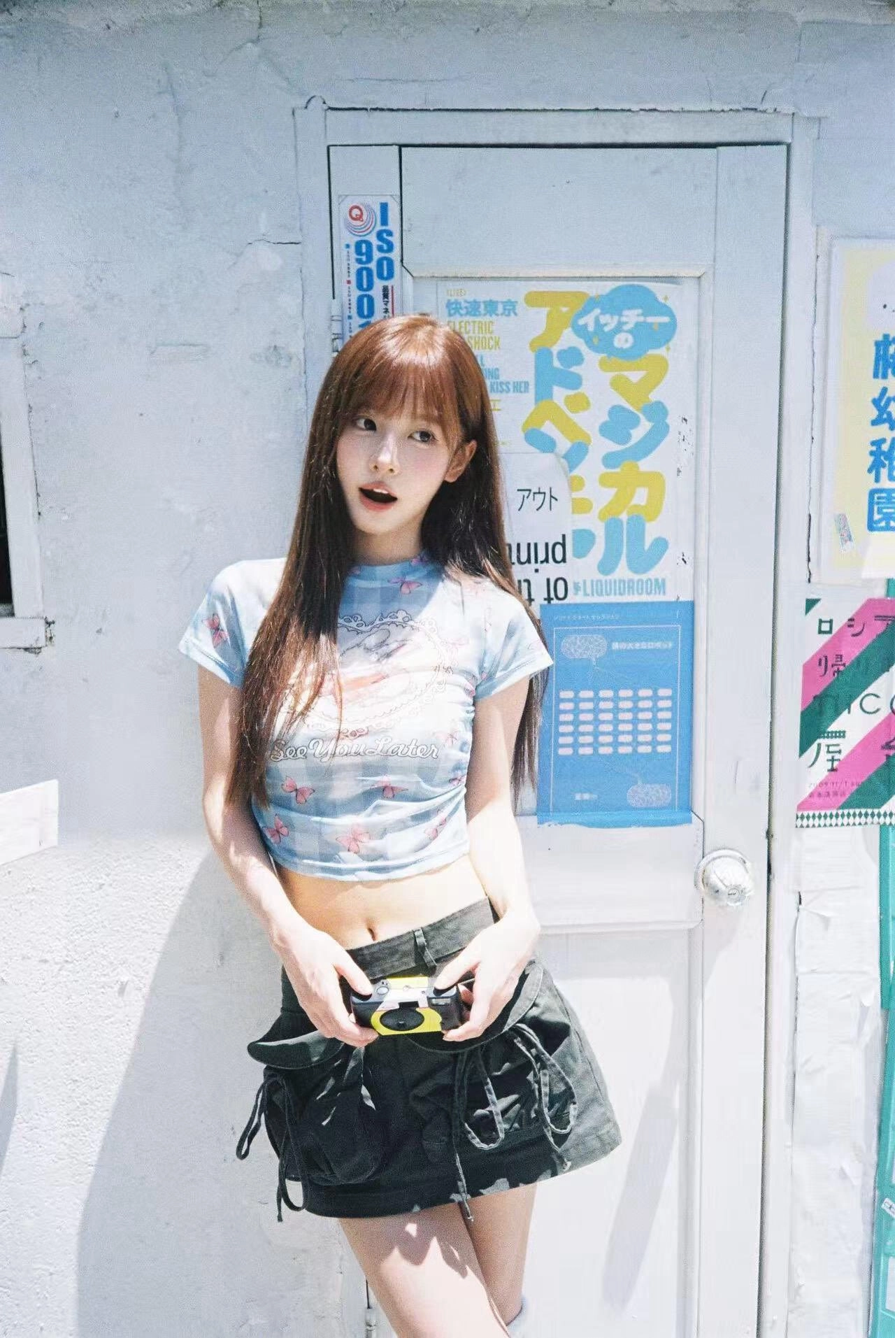 一位穿着蓝色衬衫和黑色裤子的女人拿着相机。