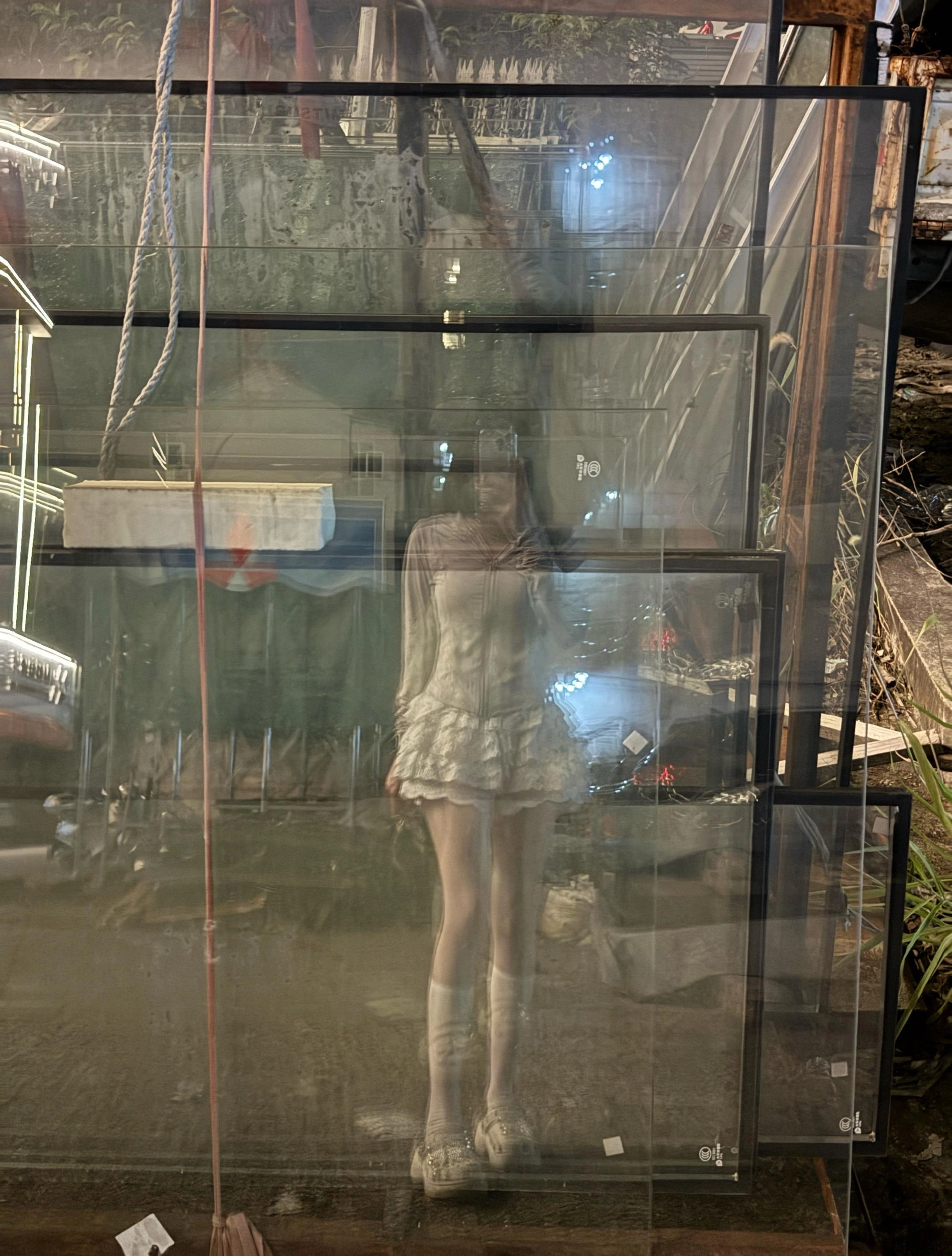 穿着白色衣服的女人在镜子里拍照自己。