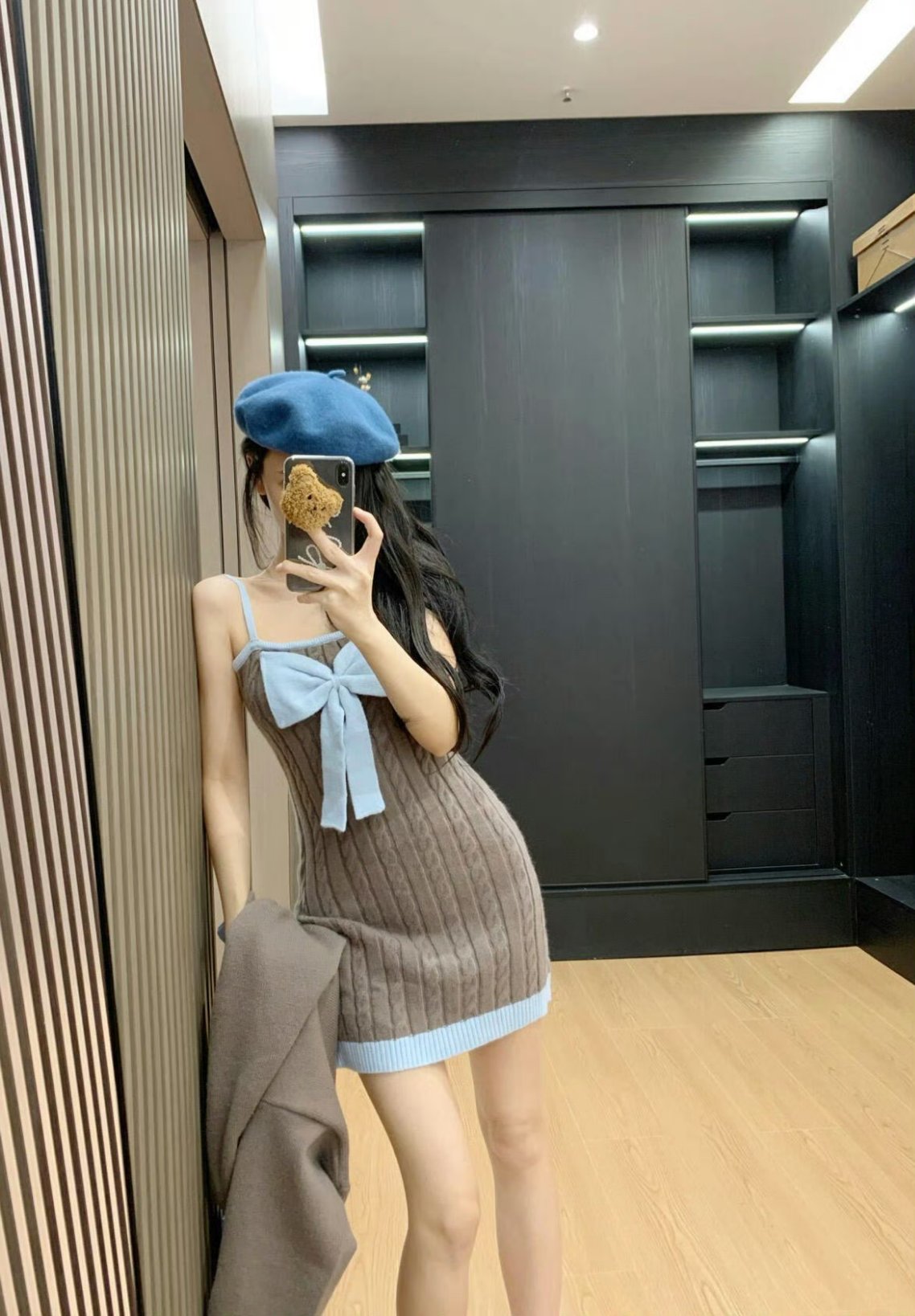 穿着蓝色帽子和棕色外套的女人拍了一张自拍。