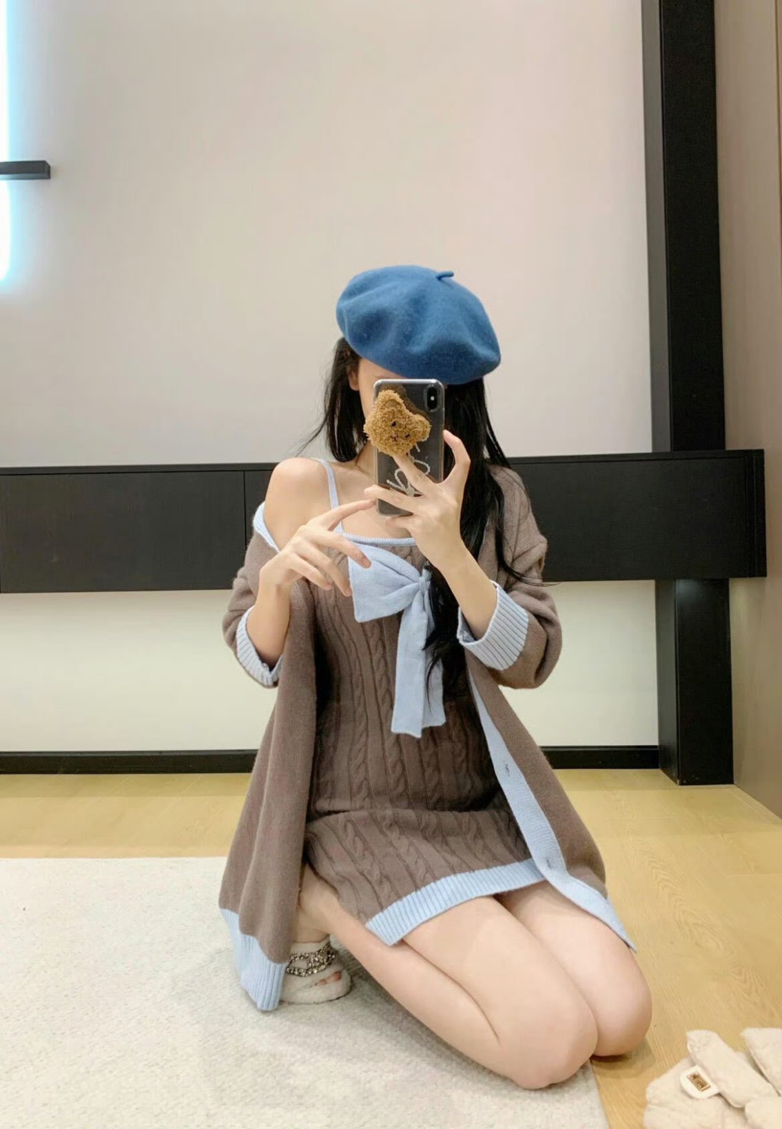 穿着蓝色帽子和棕色外套的女人拍了一张自拍。