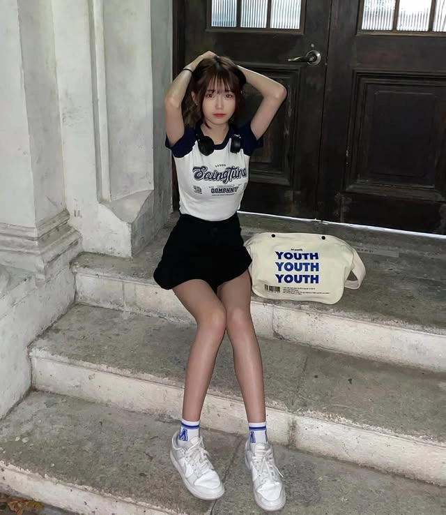 女人坐在楼梯上带着一个袋子。