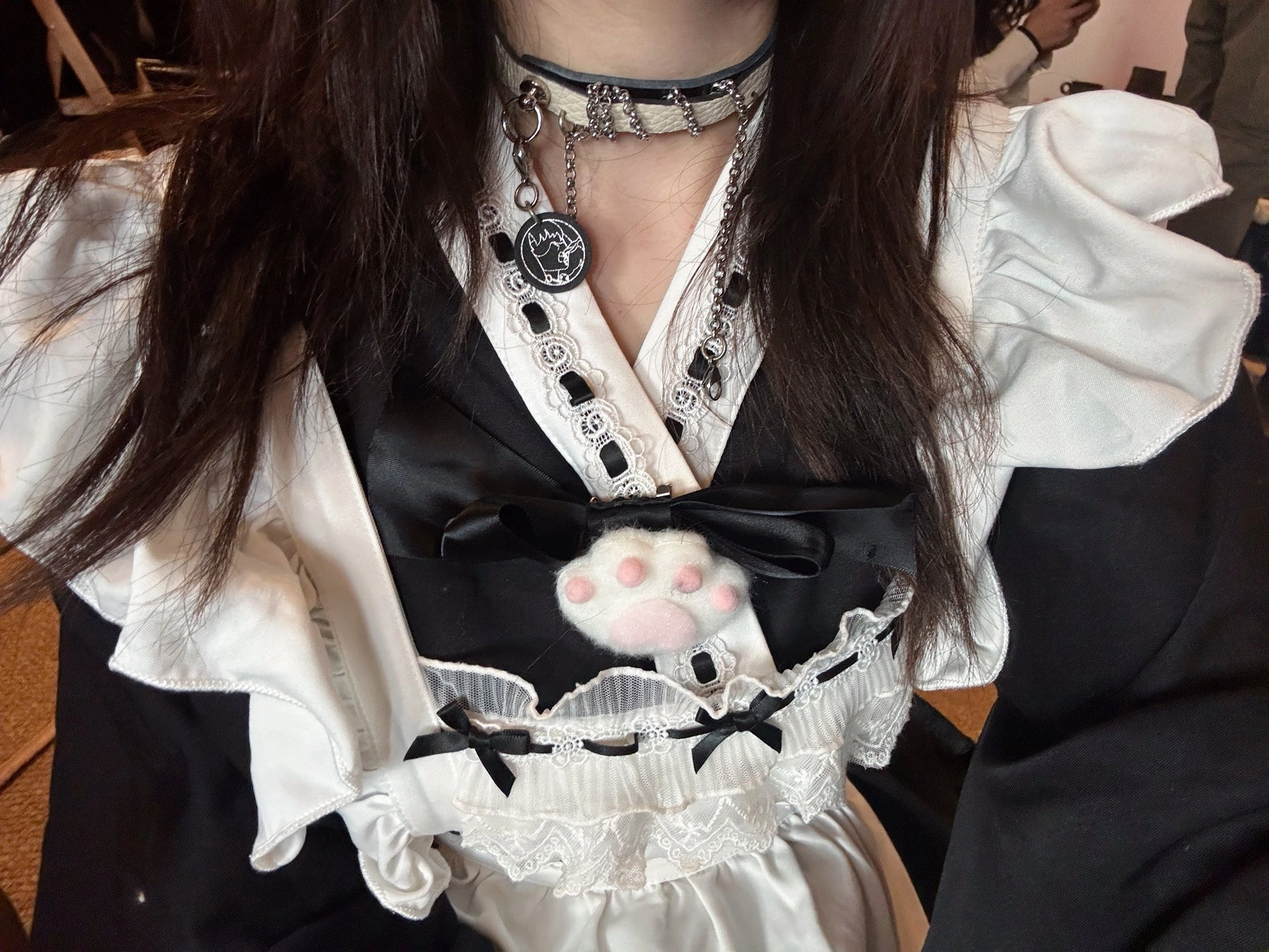 女人穿着一件黑白的裙子,胸上有一只猫。