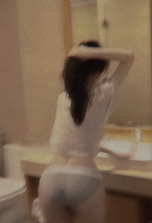 女人在镜子前刷头发。