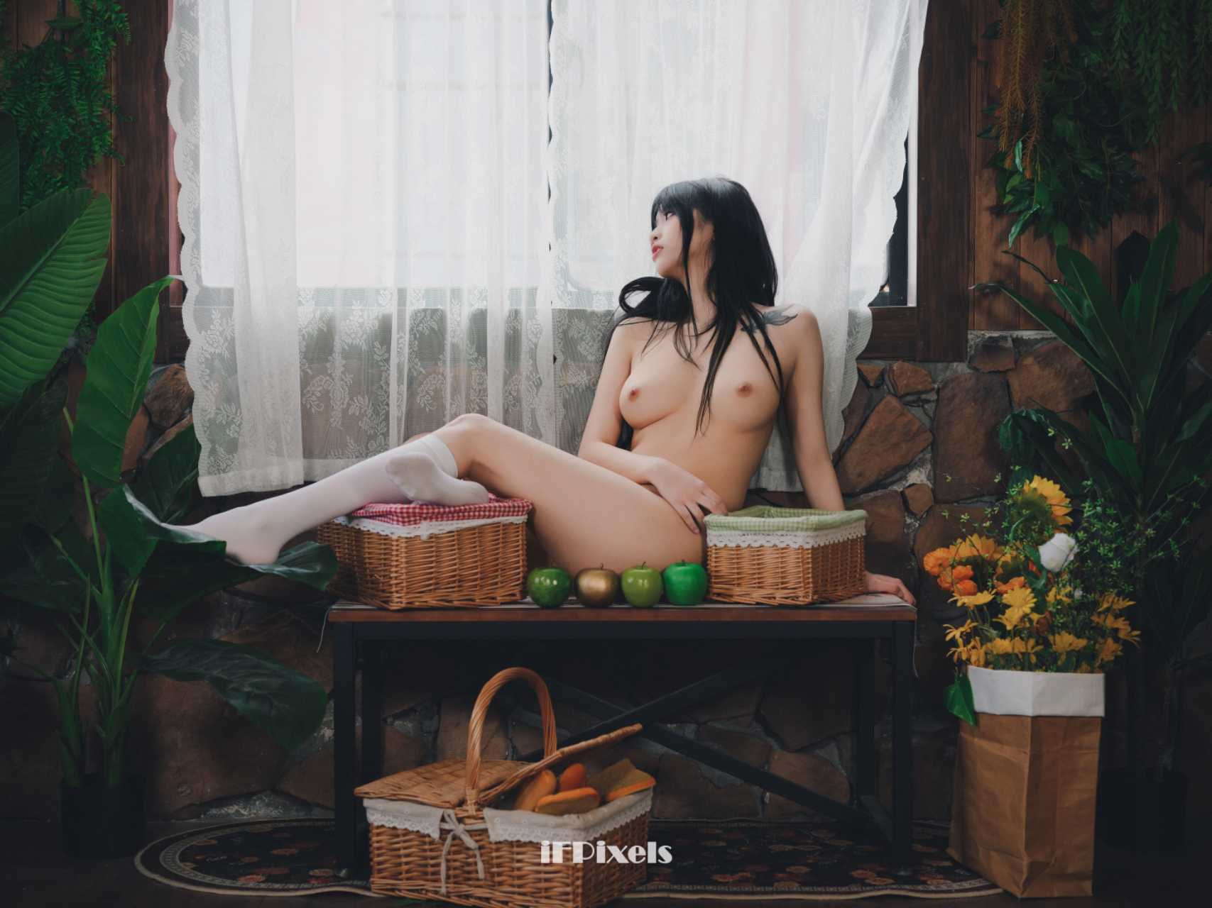 女人坐在一张桌子上,周围有水果和篮子。