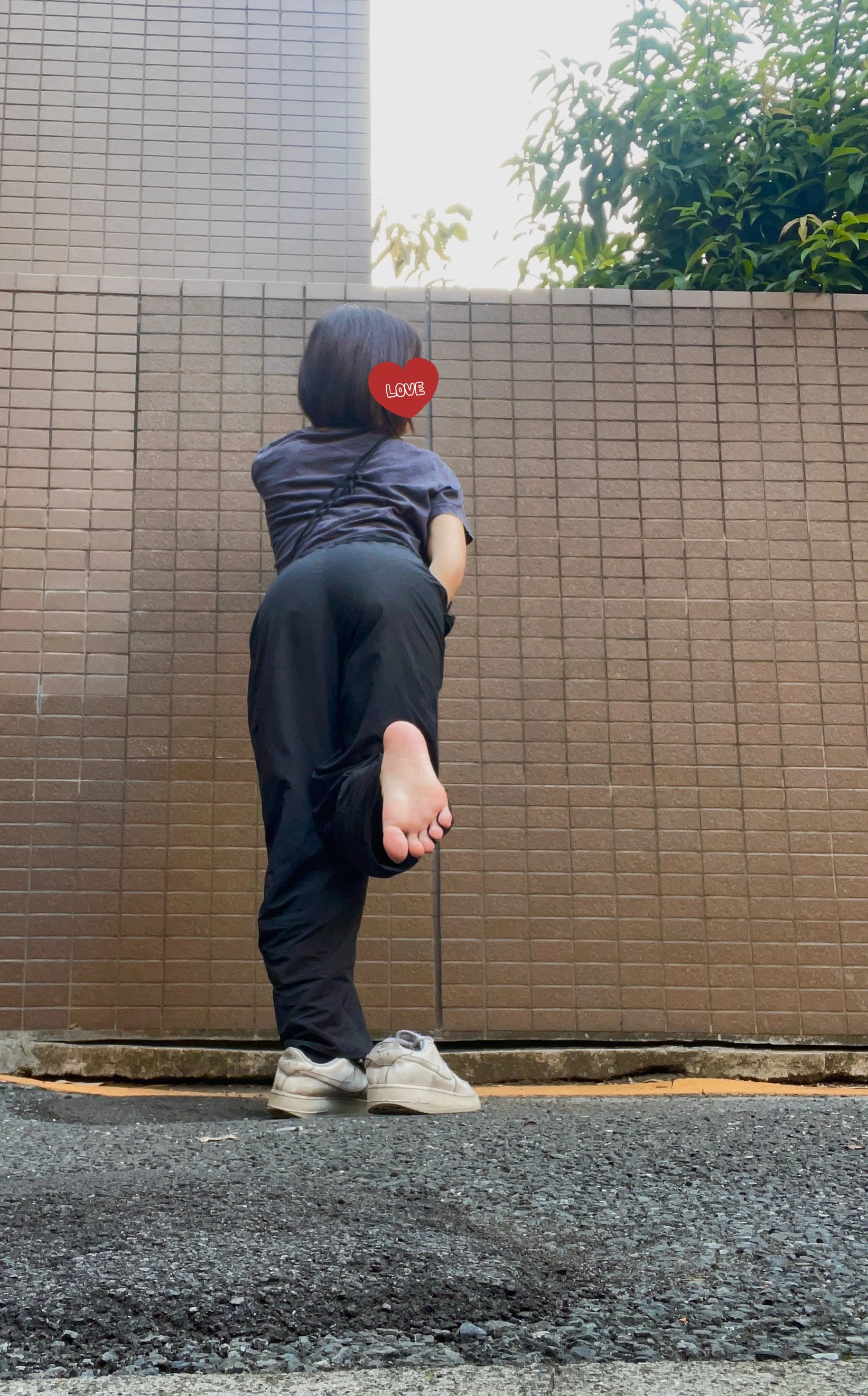 穿着黑色衬衫和黑色裤子的女人,背上有一颗红色的心。