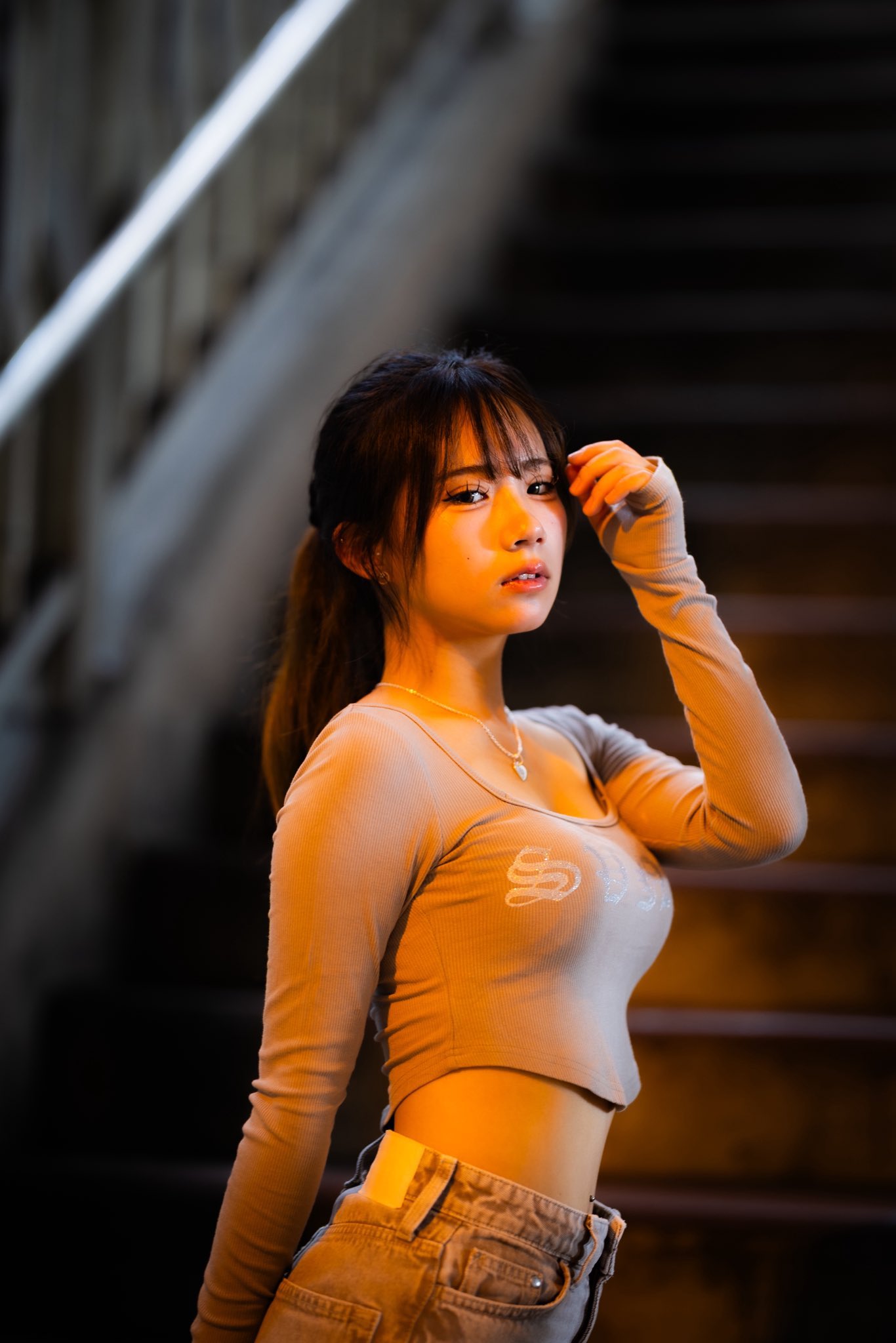 穿着灰色衬衫的女人站在楼梯上。