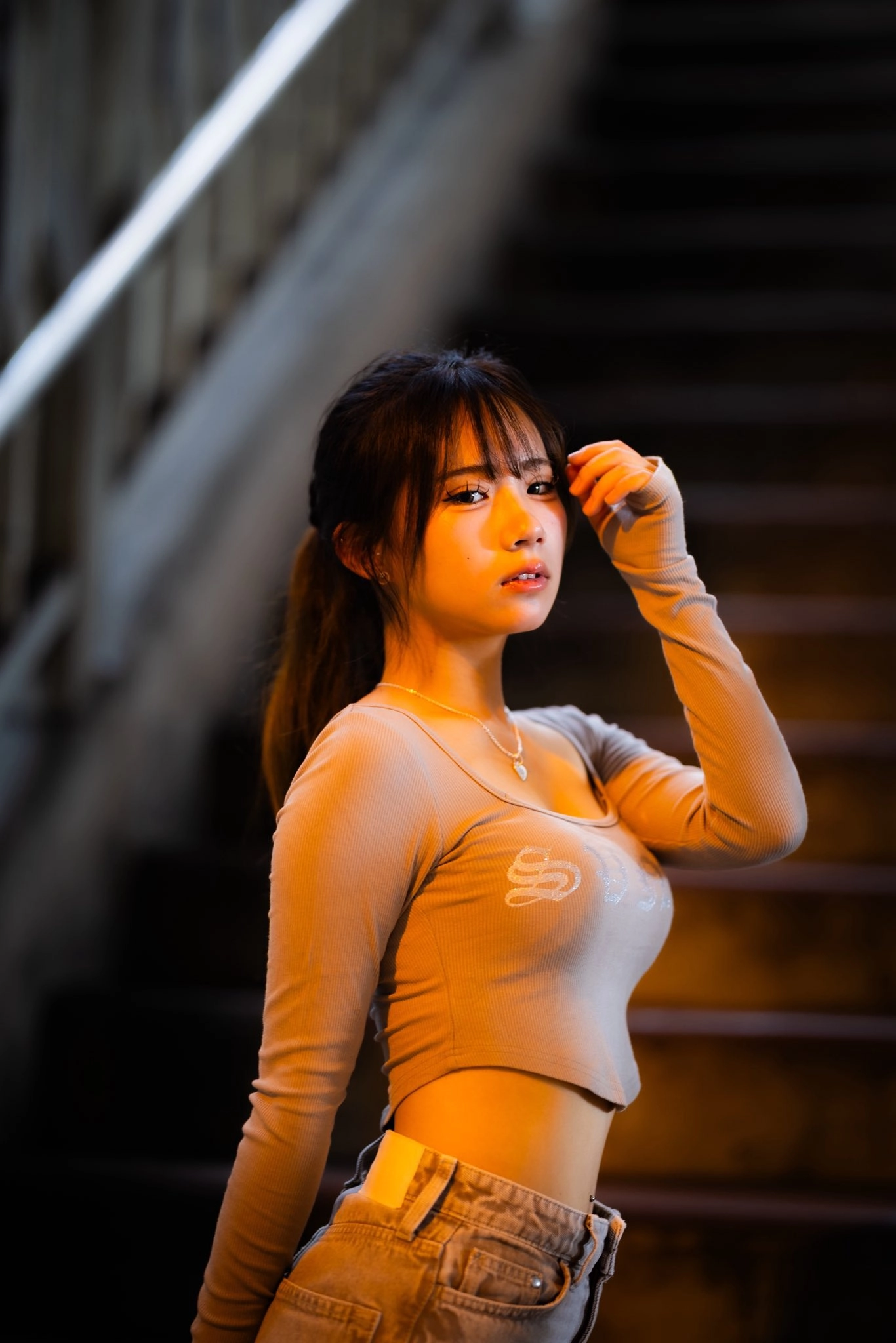 穿着灰色衬衫的女人站在楼梯上。