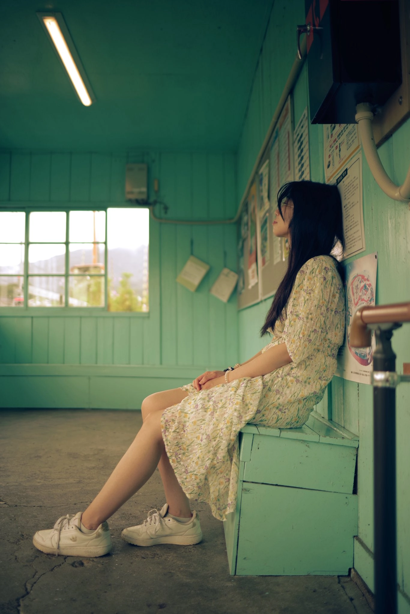 女人坐在一个蓝色房间的凳子上。