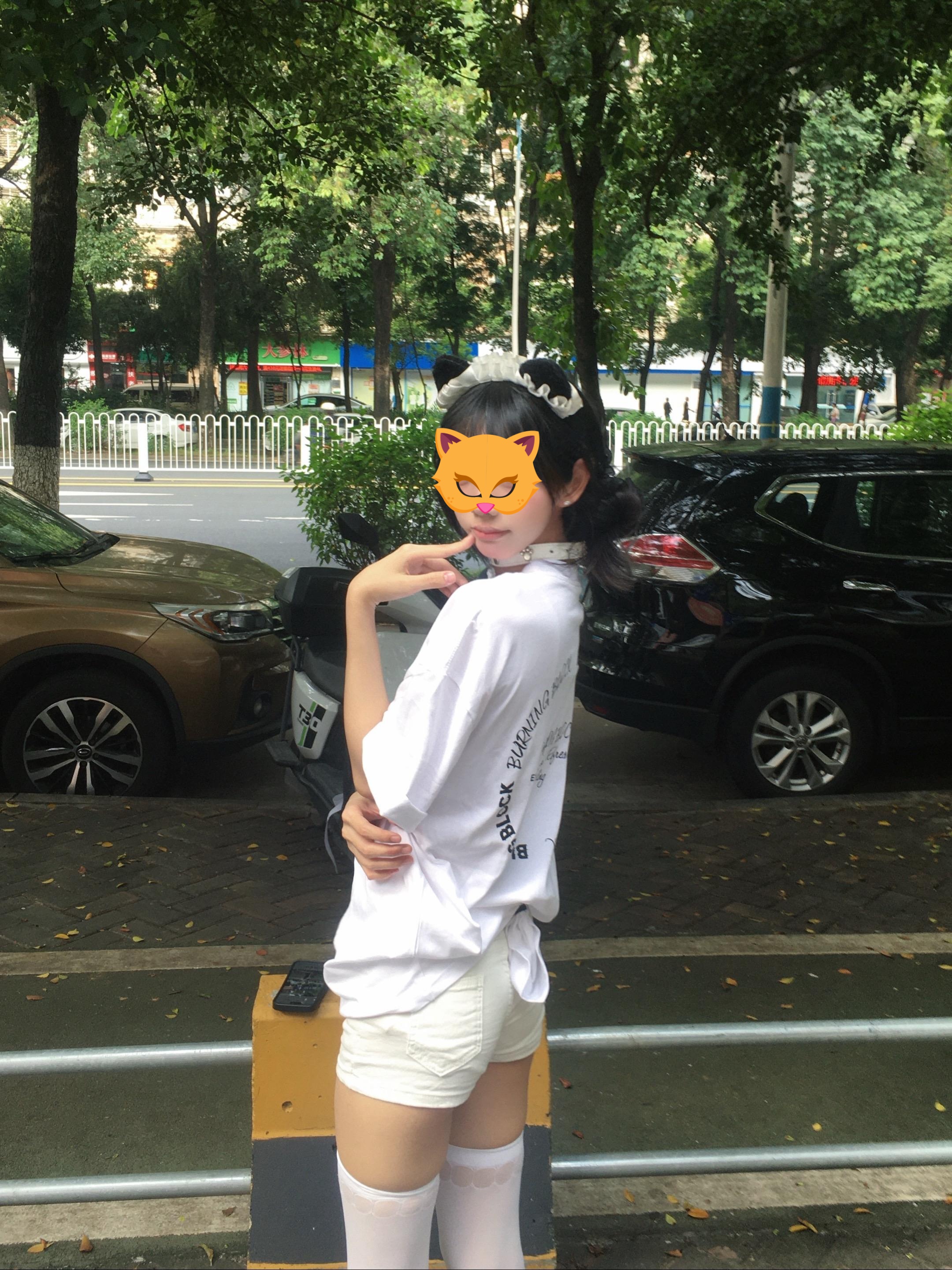 手里拿着手机的女人坐在一张凳子上。