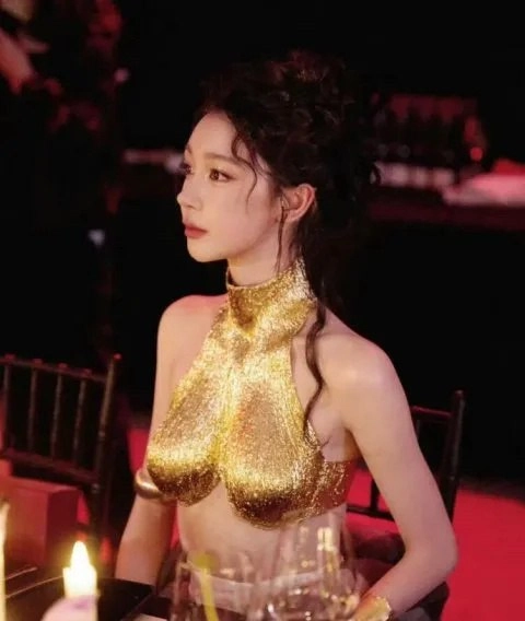 穿着黄金手的女人坐在一张桌子上。