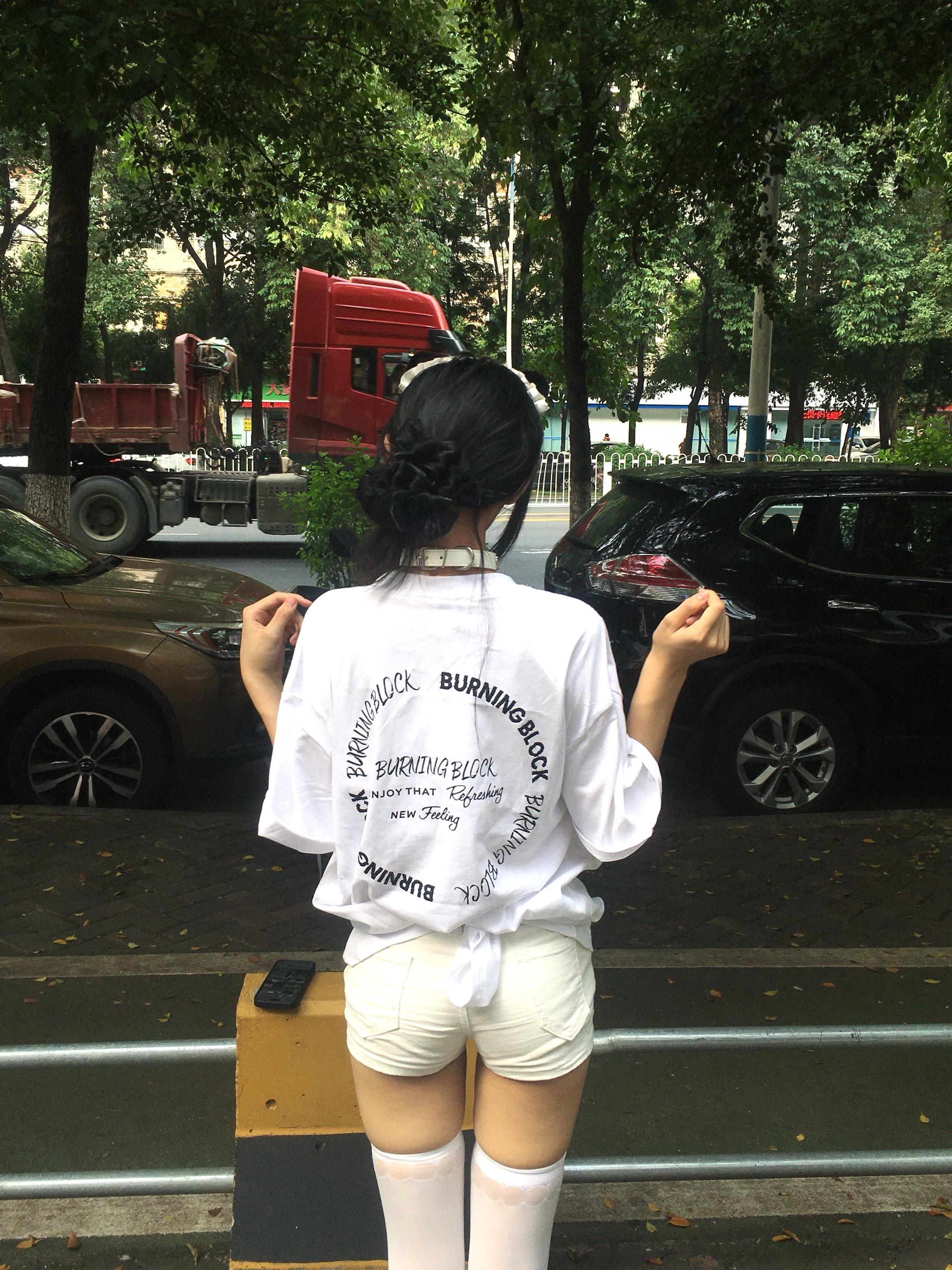 手里拿着手机的女人坐在一张凳子上。