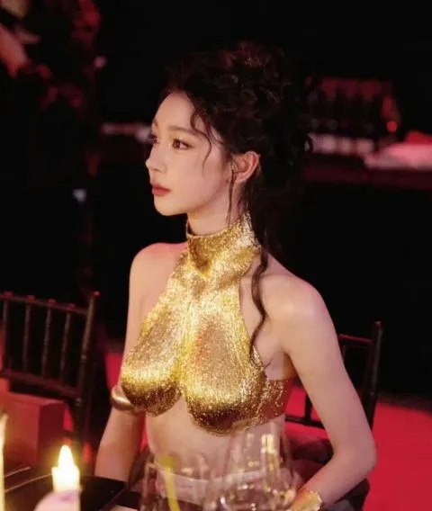 穿着黄金手的女人坐在一张桌子上。