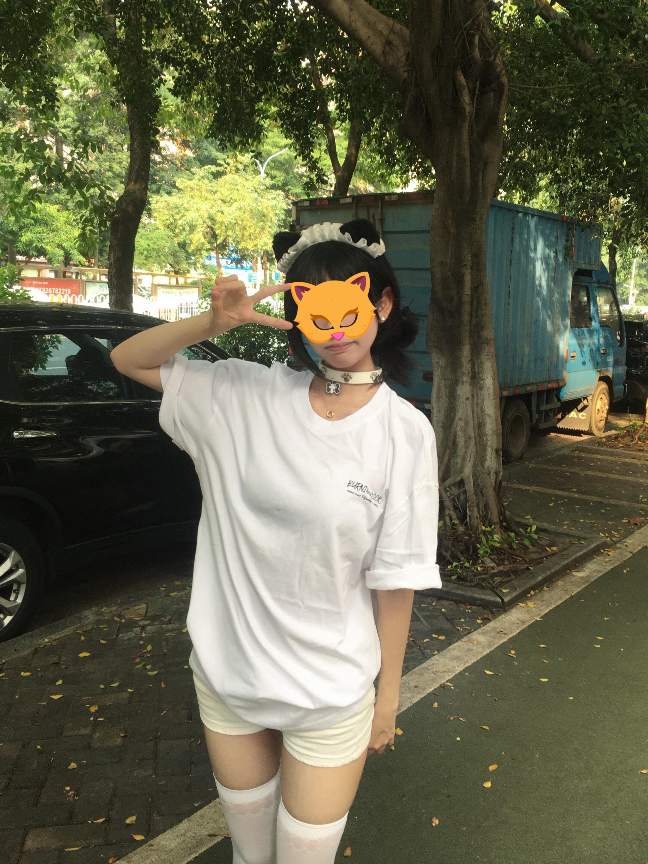 手里拿着手机的女人坐在一张凳子上。