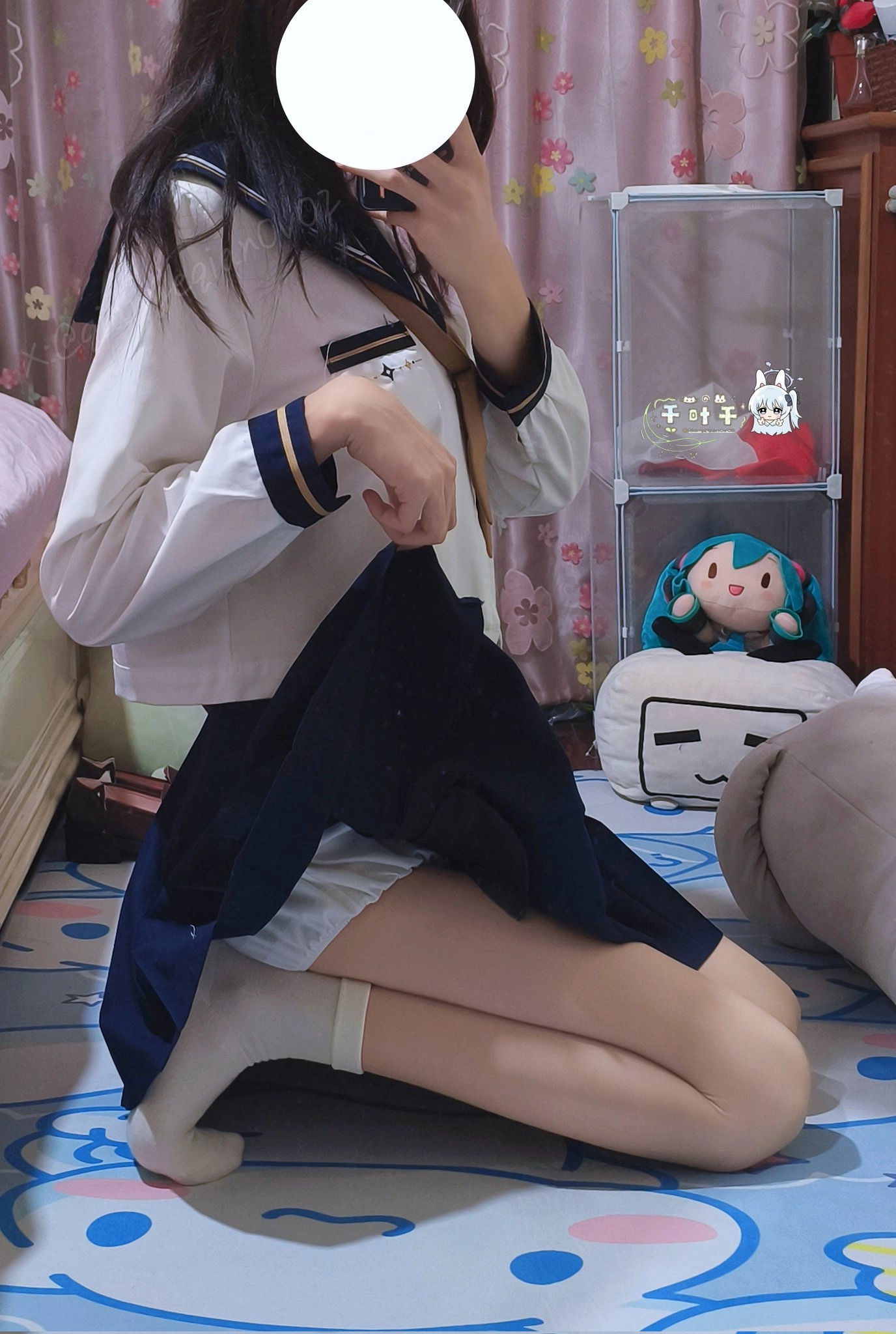 穿着水手服的女孩坐在地板上。