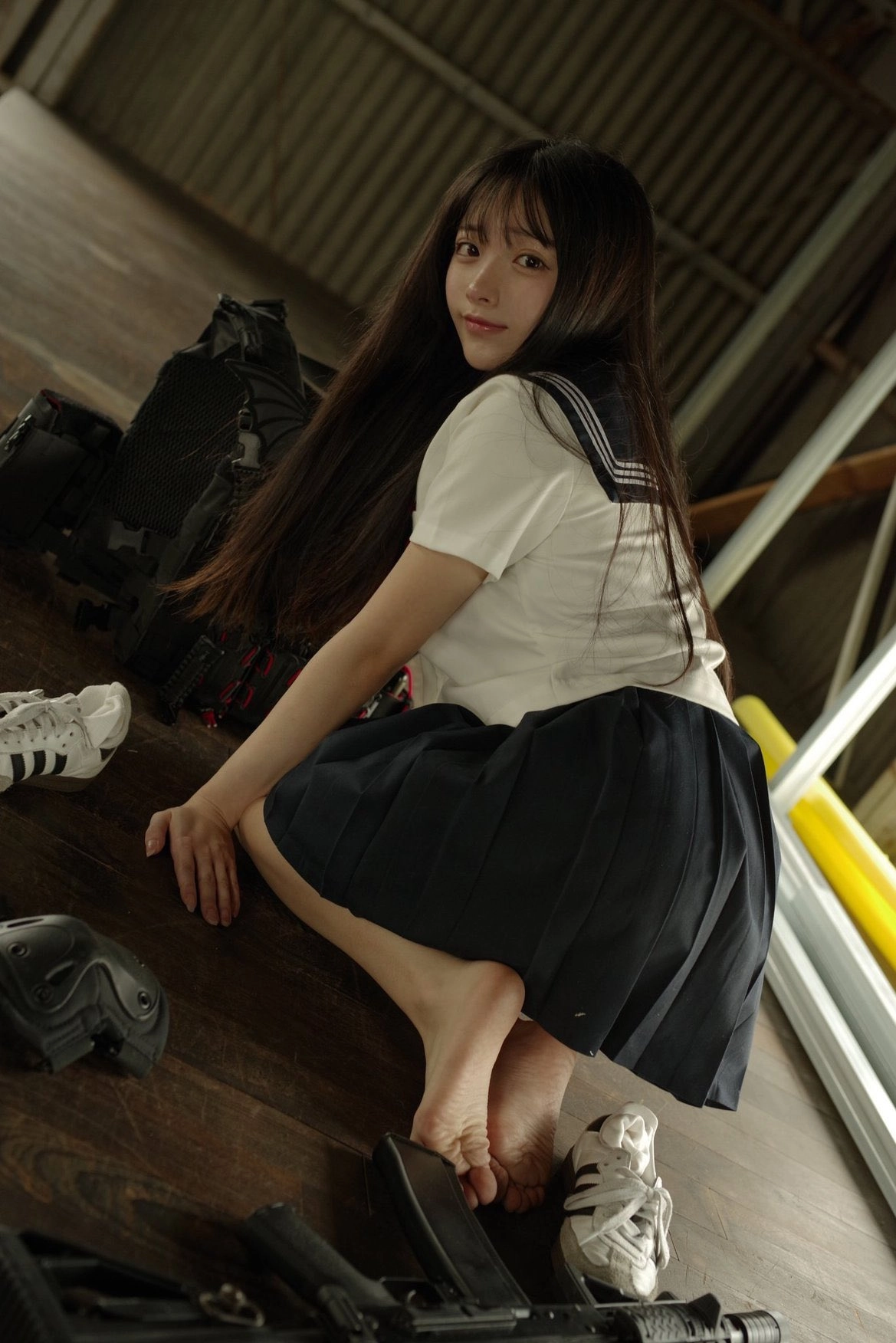 一位穿着白色衬衫和蓝色裙子的女孩坐在地板上。