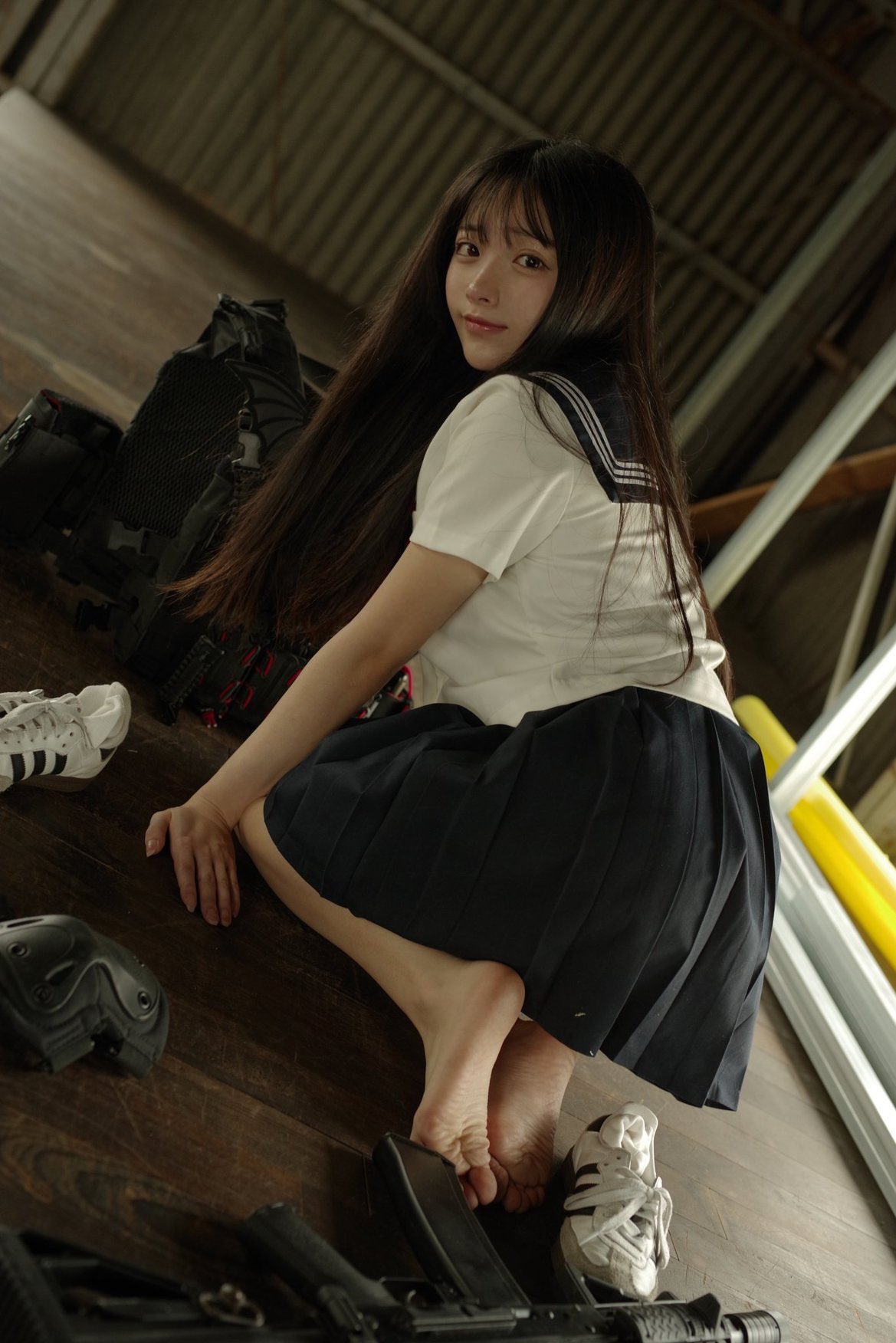 一位穿着白色衬衫和蓝色裙子的女孩坐在地板上。