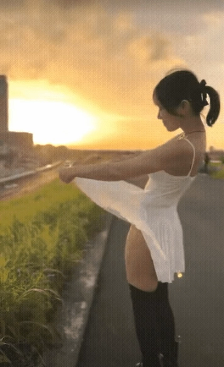 一位穿着白色衣服的女人站在街上。